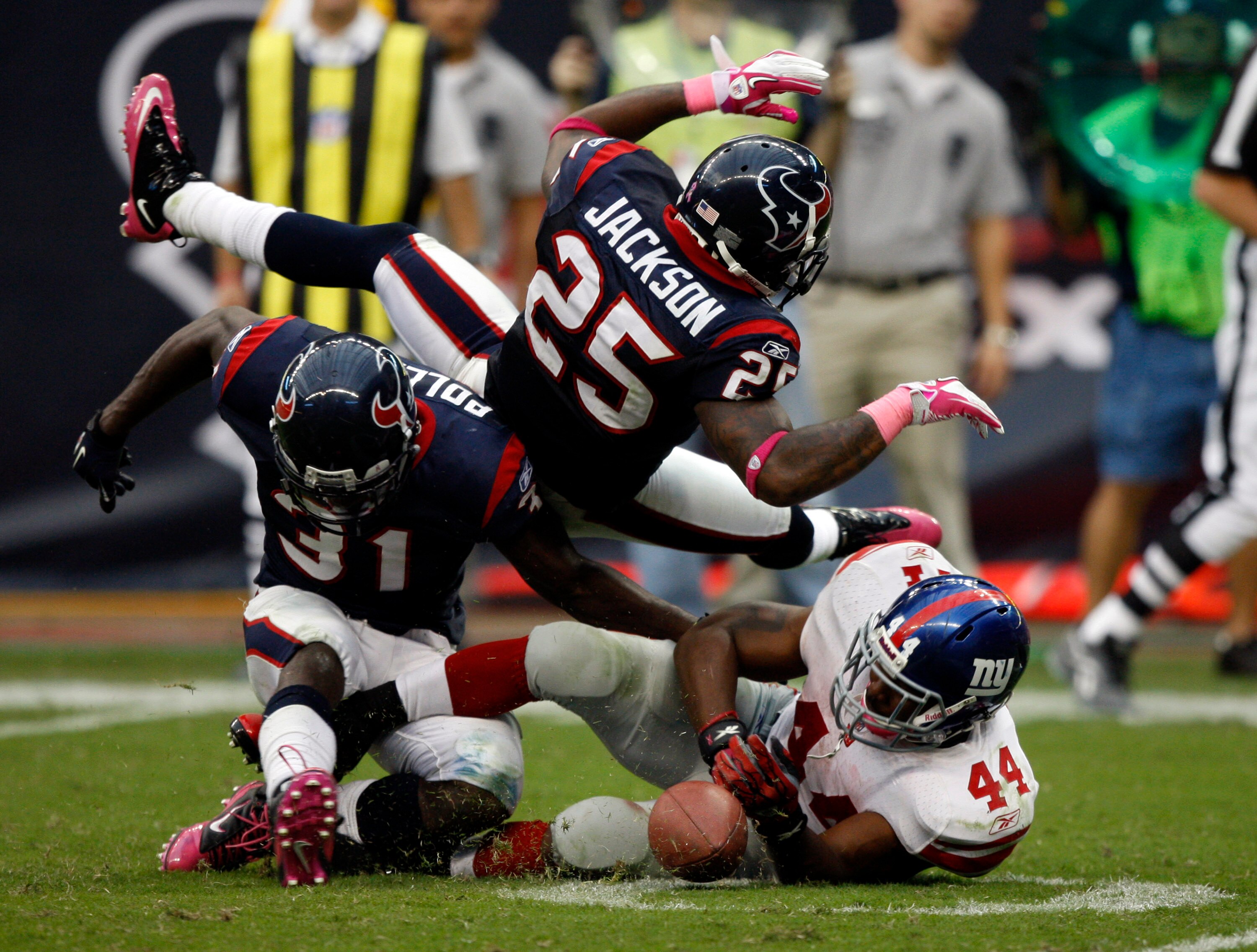 HOUSTON - OCTOBER 10:  Running back Ahmad Bradshaw #44 of the New York Giants takes a hard hit from strong safety Bernard Pollard #31 and cornerback Kareem Jackson #25 at Reliant Stadium on October 10, 2010 in Houston, Texas.  (Photo by Bob Levey/Getty Im