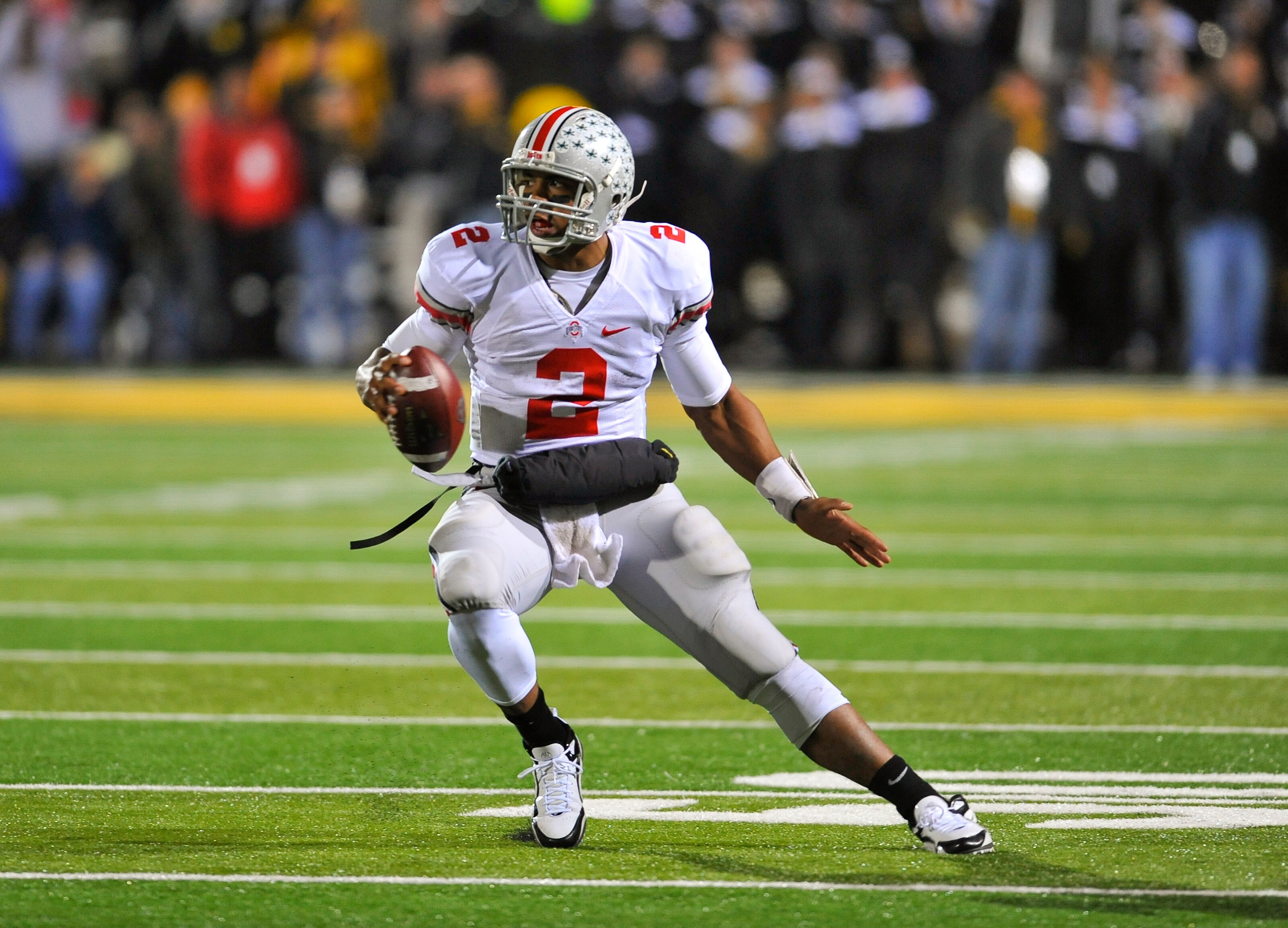 IOWA CITY, IA - NOVEMBER 20:  Quarterback Terrelle Pryor #2 of the Ohio State Buckeyes scrambles for yards under pressure from University of Iowa Hawkeyes defenders during the second half of play at Kinnick Stadium on November 20, 2010 in Iowa City, Iowa.