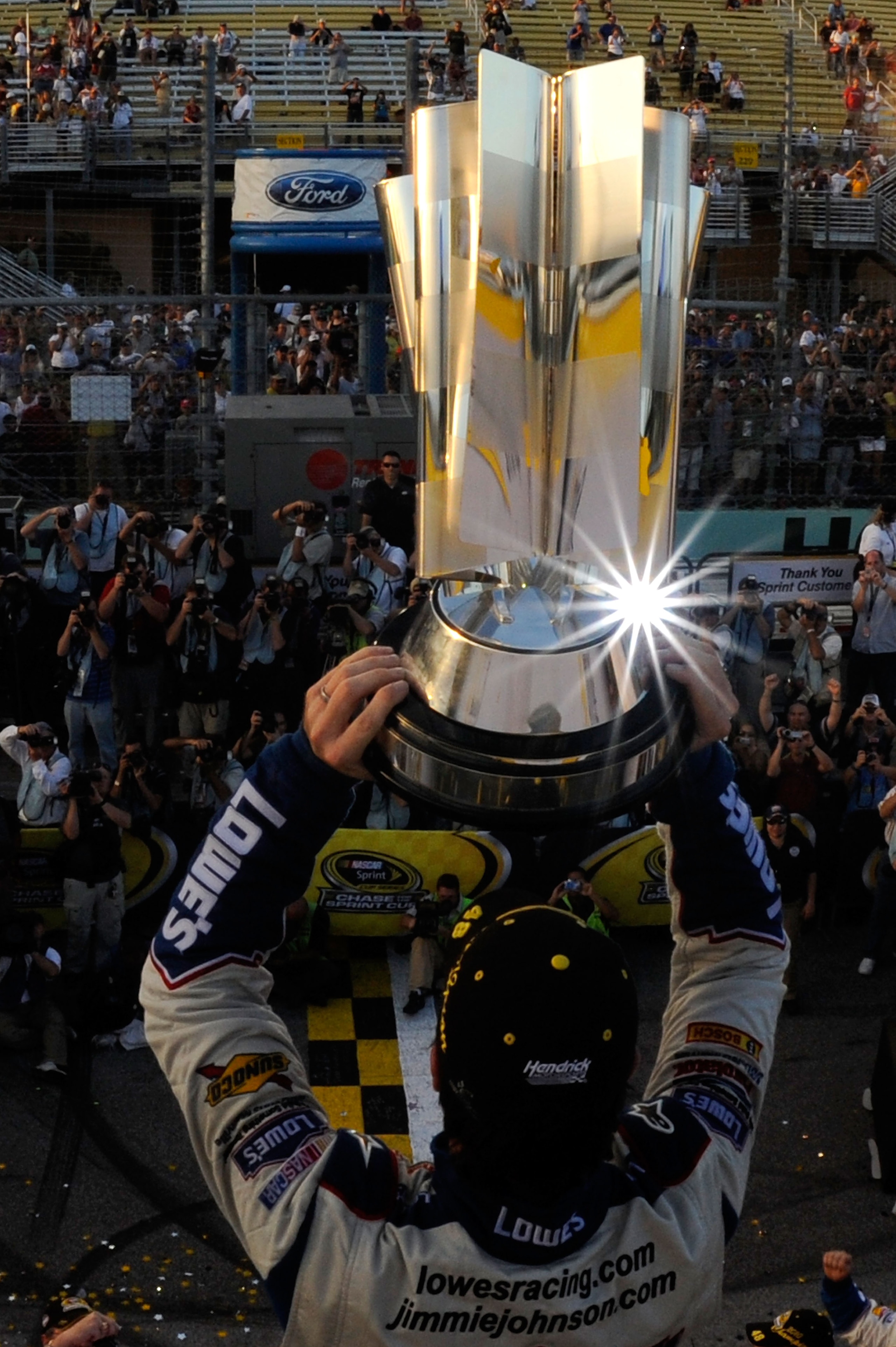 HOMESTEAD, FL - NOVEMBER 21: Jimmie Johnson, driver of the #48 Lowe's Chevrolet, celebrates by hoisting the trophy after finishing in second place in the Ford 400 to clinch his fifth consecutive NASCAR Sprint Cup championship at Homestead-Miami Speedway HOMESTEAD, FL - NOVEMBER 21: Jimmie Johnson, driver of the #48 Lowe's Chevrolet, celebrates by hoisting the trophy after finishing in second place in the Ford 400 to clinch his fifth consecutive NASCAR Sprint Cup championship at Homestead-Miami Speedway