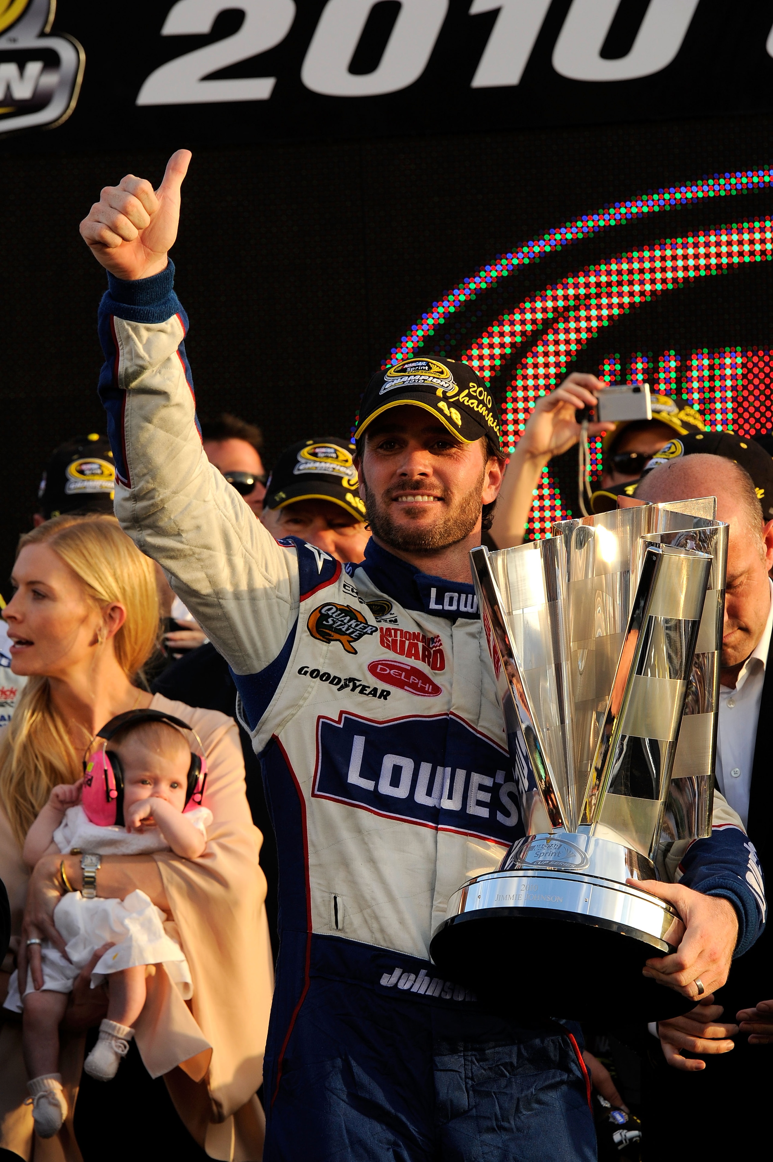 HOMESTEAD, FL - NOVEMBER 21: Jimmie Johnson, driver of the #48 Lowe's Chevrolet, celebrates after finishing in second place in the Ford 400 to clinch his fifth consecutive NASCAR Sprint Cup championship as his wife Chandra (L) and daughter Genevieve look HOMESTEAD, FL - NOVEMBER 21: Jimmie Johnson, driver of the #48 Lowe's Chevrolet, celebrates after finishing in second place in the Ford 400 to clinch his fifth consecutive NASCAR Sprint Cup championship as his wife Chandra (L) and daughter Genevieve look