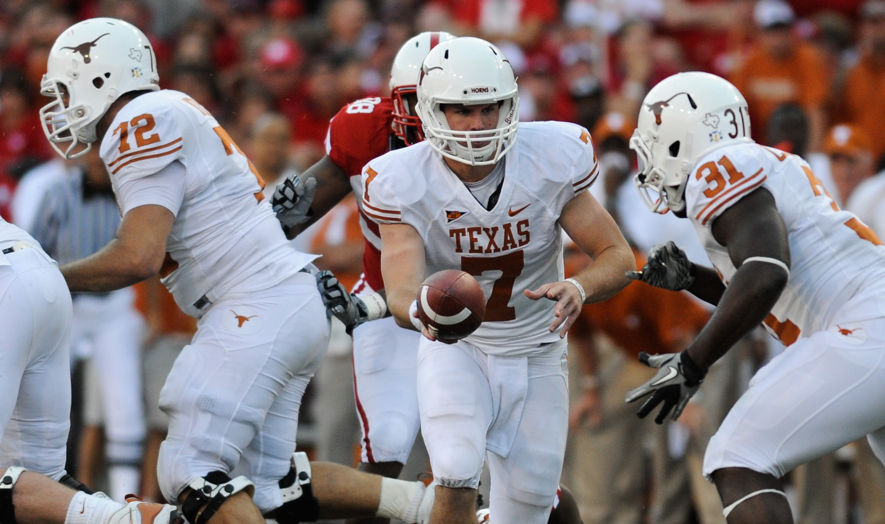 LINCOLN, NE - OCTOBER 16: Quarterback Garrett Gilbert #7 of the Texas Longhorns hand the ball to teammate running back Cody Johnson #31 during second half action of their game at Memorial Stadium on October 16, 2010 in Lincoln, Nebraska. Texas Defeated Ne
