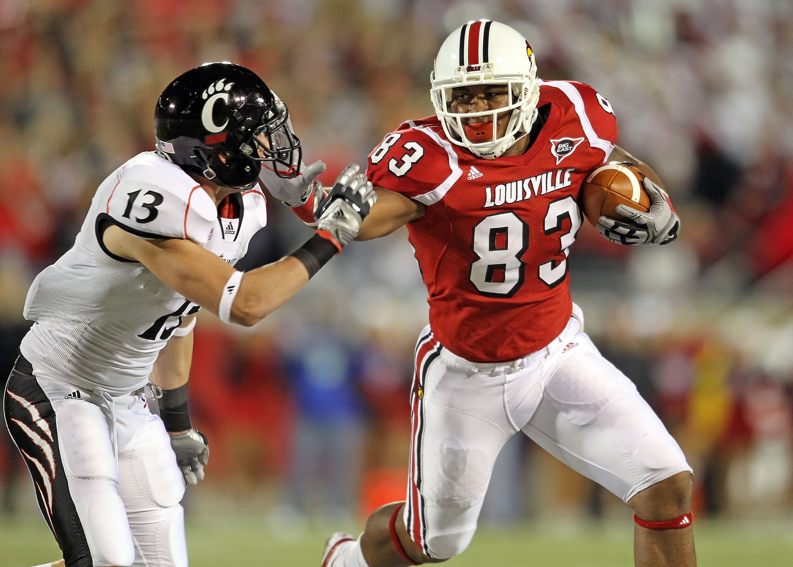 LOUISVILLE, KY - OCTOBER 15:  Cameron Graham #83 of the Louisville Cardinals runs with the ball while defended by Cody Kater #13 of the Cincinnati Bearcats during the game at Papa John's Cardinal Stadium on October 15, 2010 in Louisville, Kentucky.  (Phot