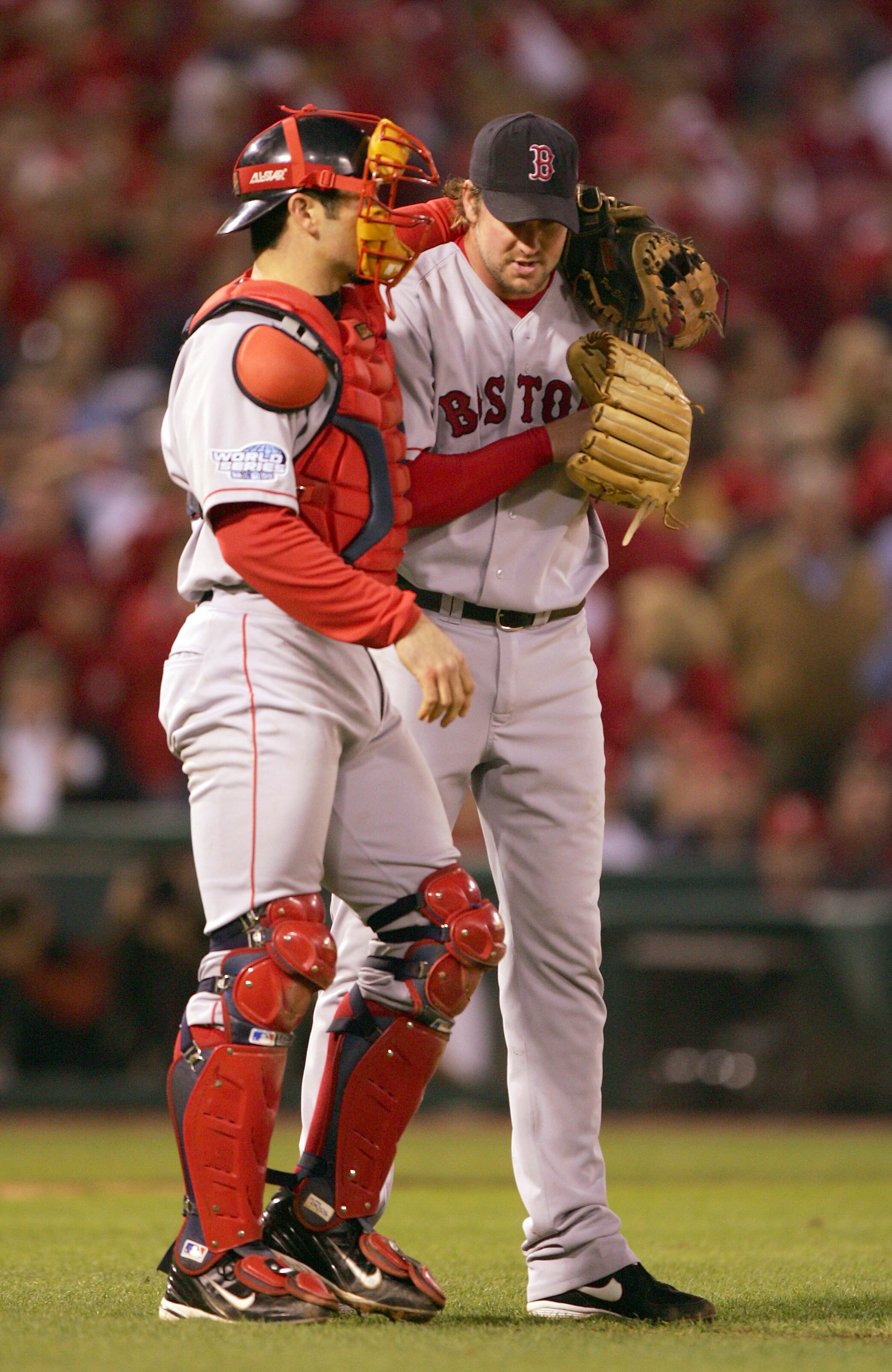 ST LOUIS - OCTOBER 27:  Catcher Jason Varitek #33 of the Boston Red Sox talks with pitcher Derek Lowe #32 during game four of the World Series against the St. Louis Cardinals on October 27, 2004 at Busch Stadium in St. Louis, Missouri. (Photo by Jed Jacob