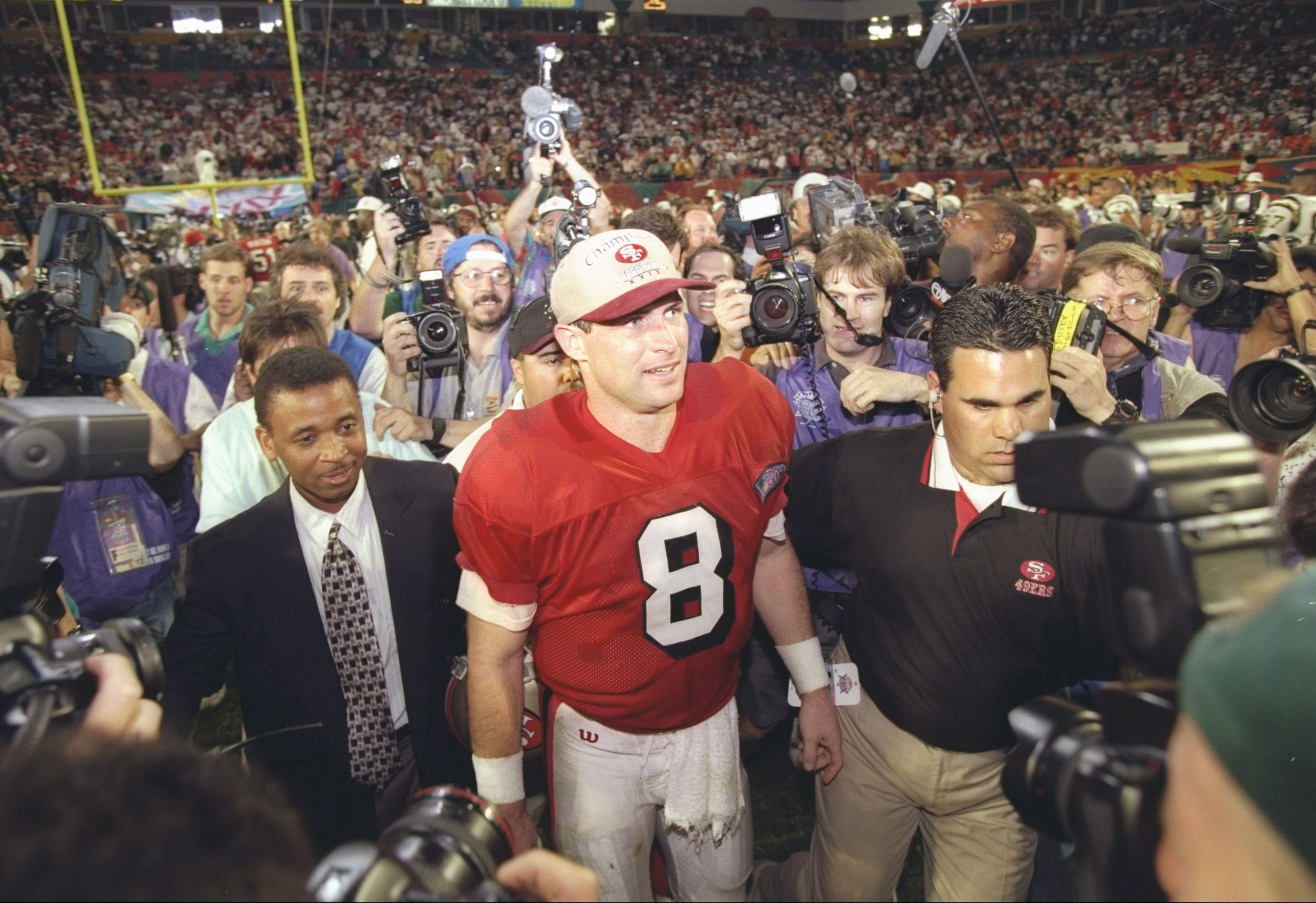 29 Jan 1995:   Quarterback Steve Young #8 of the San Francisco 49ers is surrounded by a cheering crowd after the 49ers defeated the San Diego Chargers at Super Bowl XXIX at the Joe Robbie Stadium in Miami,  Florida.  Young was named MVP and the 49ers won