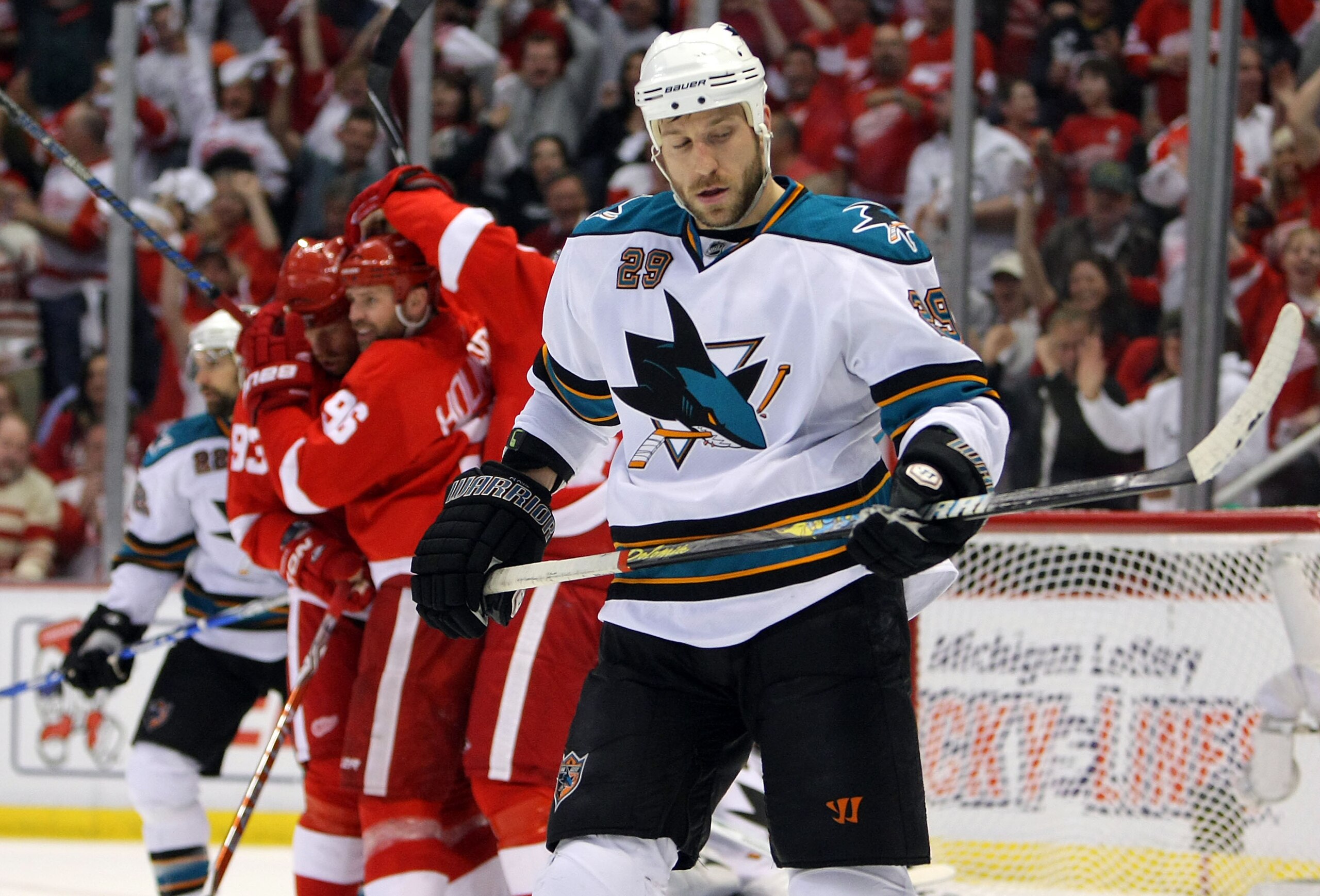 DETROIT - MAY 4:  Ryane Clowe #29 of the San Jose Sharks skates back to the bench as Tomas Holmstrom #96 of the Detroit Red Wings is congratulated by his teammates  after scoring during the first period in Game Three of the Western Conference Semifinals d