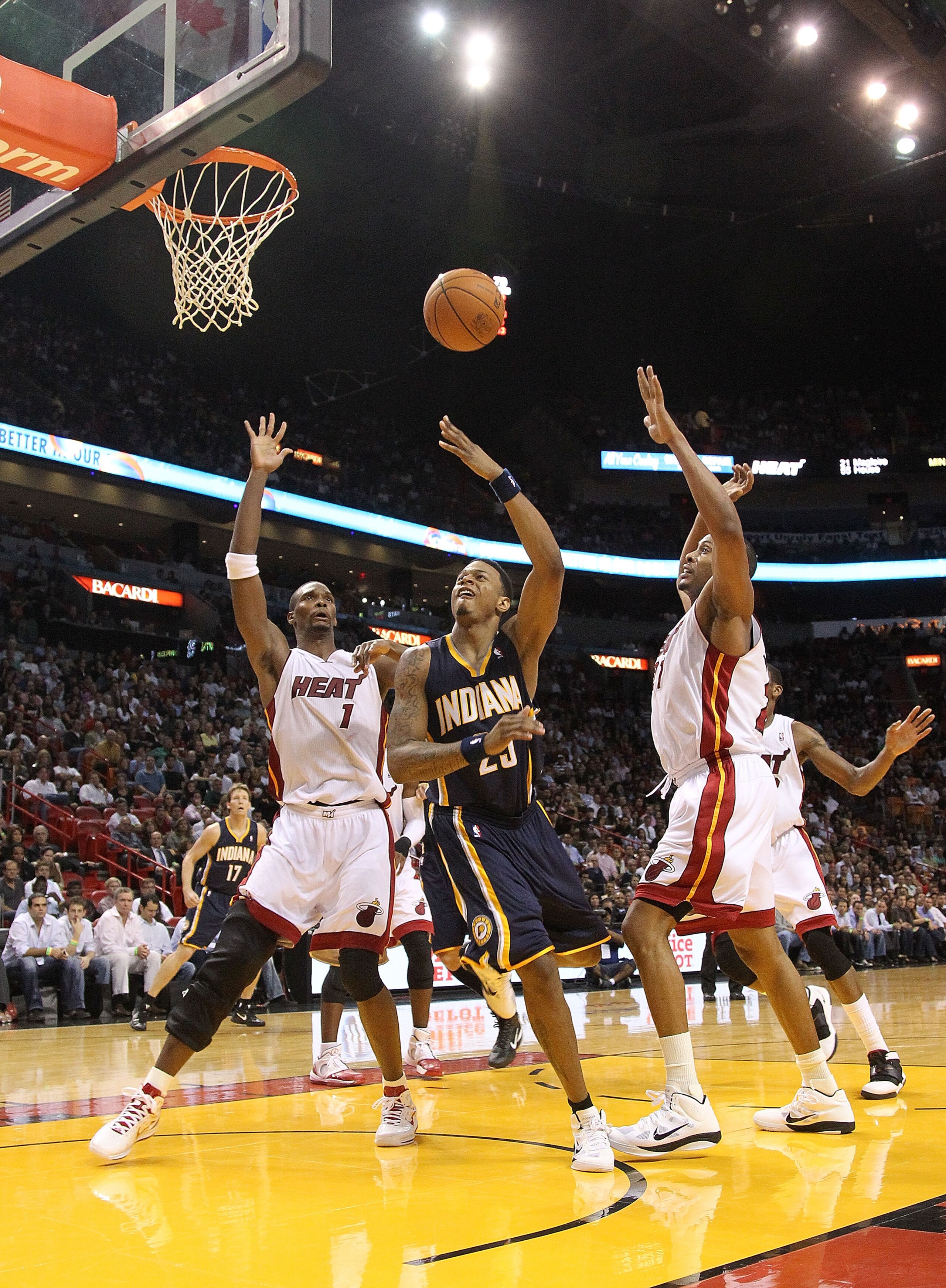 MIAMI - NOVEMBER 22:  Brandon Rush of the Indiana Pacers shoots over Chris Bosh #1 of the Miami Heat during a game at American Airlines Arena on November 22, 2010 in Miami, Florida. NOTE TO USER: User expressly acknowledges and agrees that, by downloading