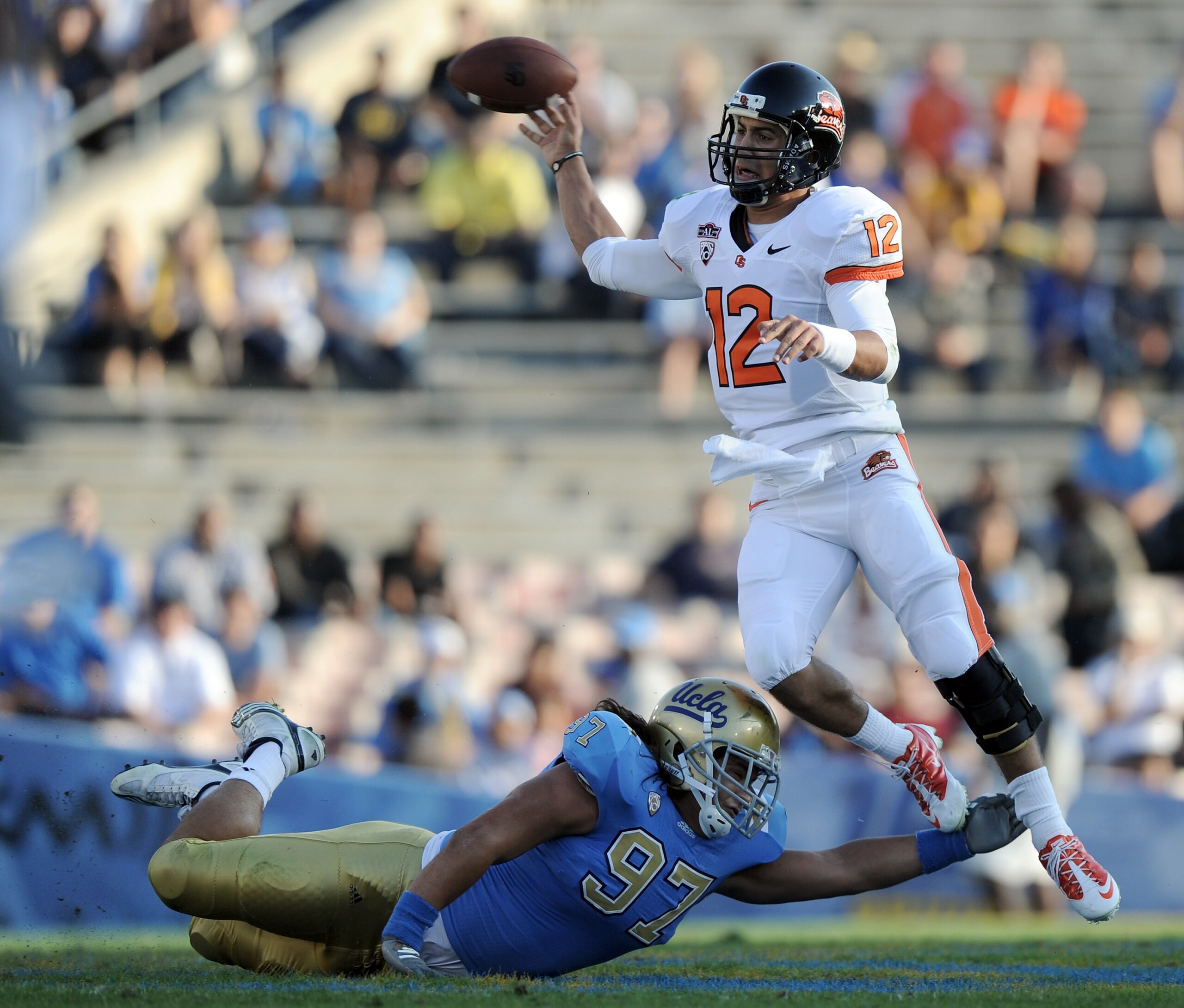PASADENA, CA - NOVEMBER 06:  Ryan Katz #12 of the Oregon State Beavers throws as he jumps the tackle from Damien Holmes #97 of the UCLA Bruins during the first quarter at the Rose Bowl on November 6, 2010 in Pasadena, California.  (Photo by Harry How/Gett