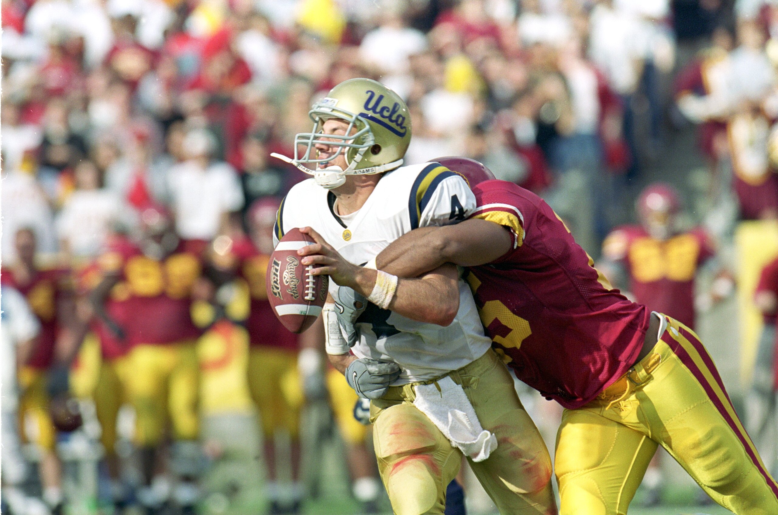 20 Nov 1999: Ryan McCann #4 of the UCLA Bruins is sacked by Lonnie Ford #25 of the USC Trojans at the Los Angeles Memorial Coliseum in Los Angeles, California. The Trojans defeated the Bruins 17-7.