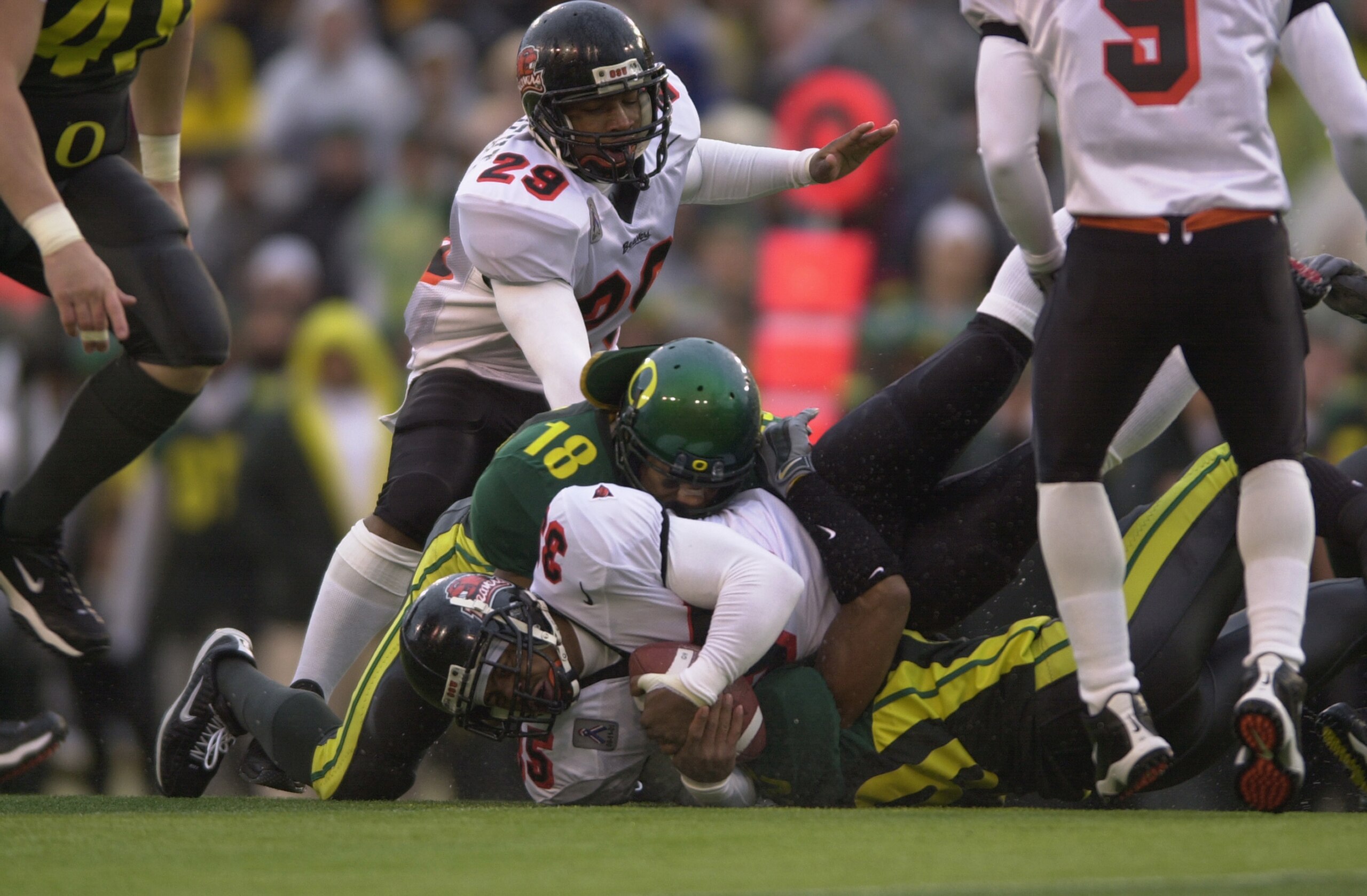 EUGENE, OR - DECEMBER 1:  Tailback Ken Simonton #35 of the Oregon State Beavers is tackled by linebacker Wesley Mallard #18 and safety Marley Tucker #28 of the Oregon Ducks during the game at Autzen Stadium in Eugene Oregon on December 1, 2001.  Oregon de