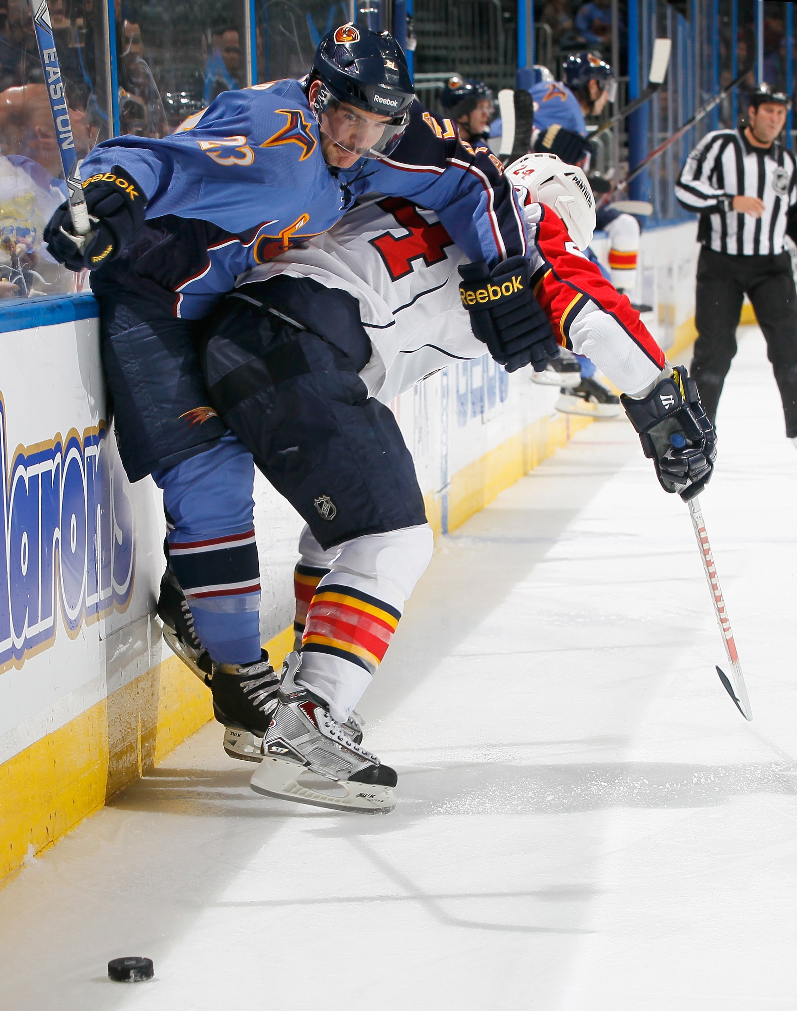 ATLANTA - NOVEMBER 17:  Jim Slater #23 of the Atlanta Thrashers is checked into the boards by Bryan McCabe #24 of the Florida Panthers at Philips Arena on November 17, 2010 in Atlanta, Georgia.  (Photo by Kevin C. Cox/Getty Images)