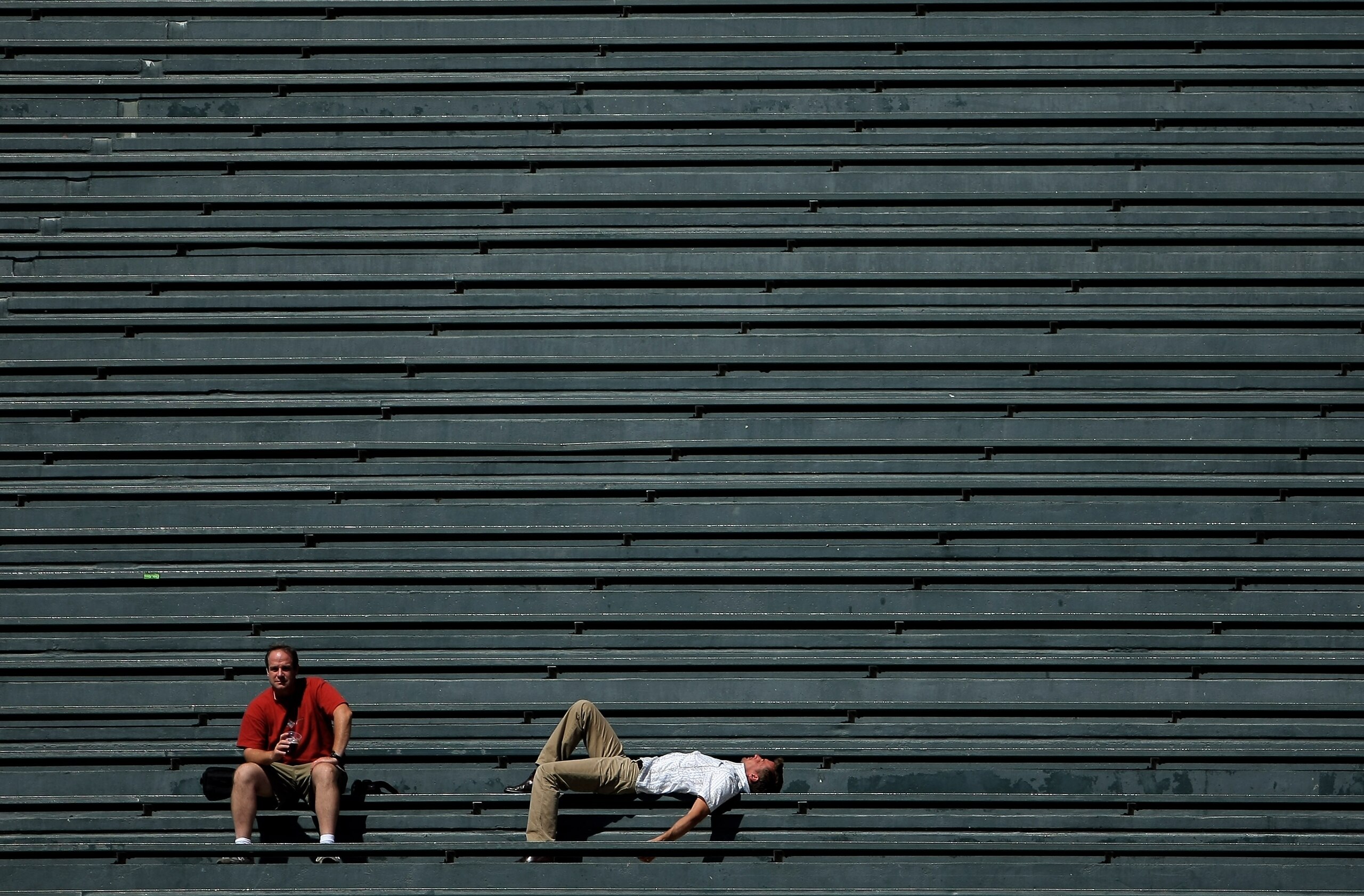 DENVER - SEPTEMBER 18:  Two fans in the vacant centerfield bleachers bask in the warm sun on a late summer afternoon as the Colorado Rockies host the Los Angeles Dodgers at Coors Field on September 18, 2007 in Denver, Colorado. The Rockies defeated the Do
