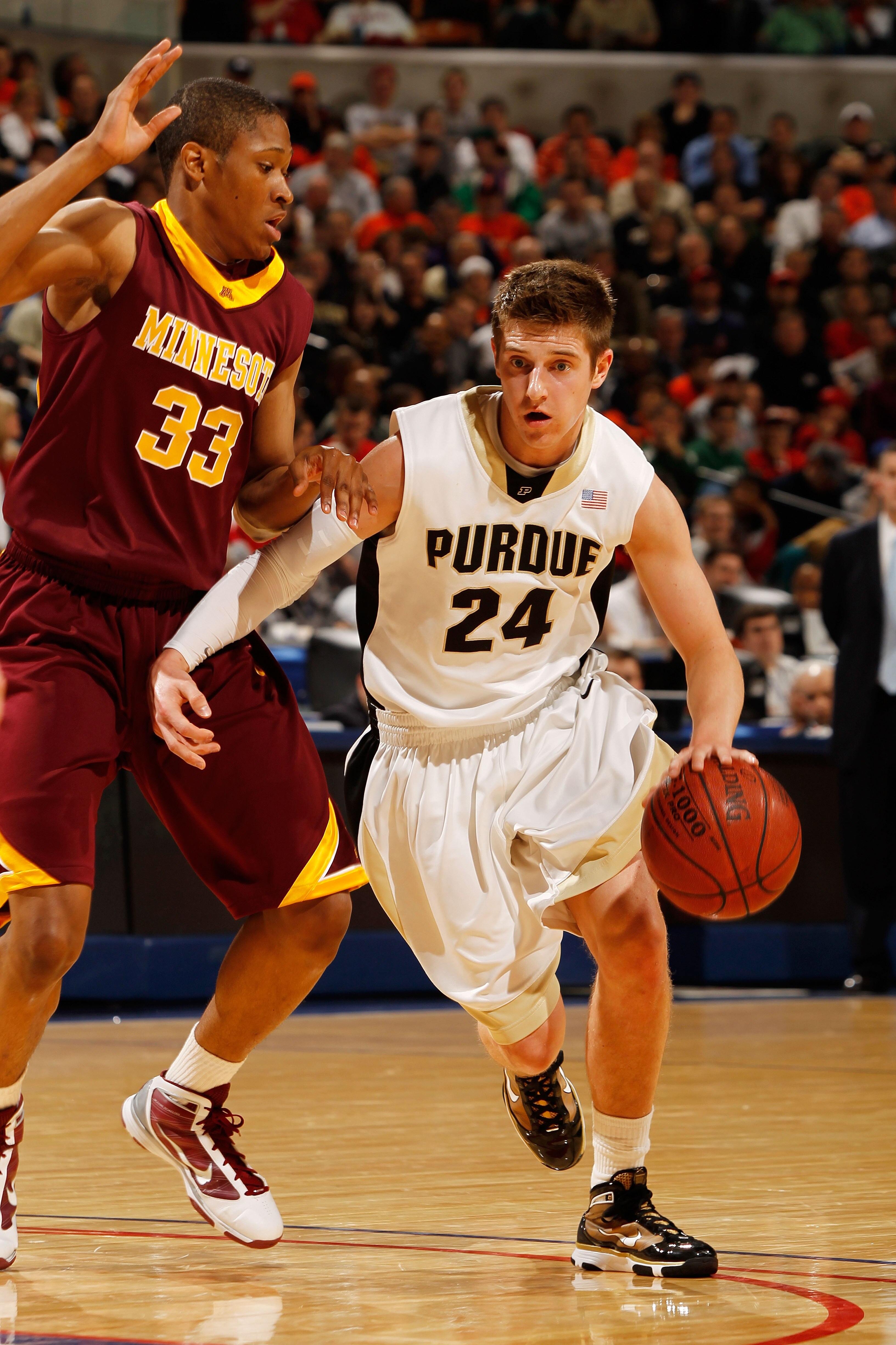 INDIANAPOLIS - MARCH 13:  Guard Ryne Smith #24 of the Purdue Boilermakers drives against forward Rodney Williams #33 of the Minnesota Golden Gophers in the semifinals of the Big Ten Men's Basketball Tournament at Conseco Fieldhouse on March 13, 2010 in In