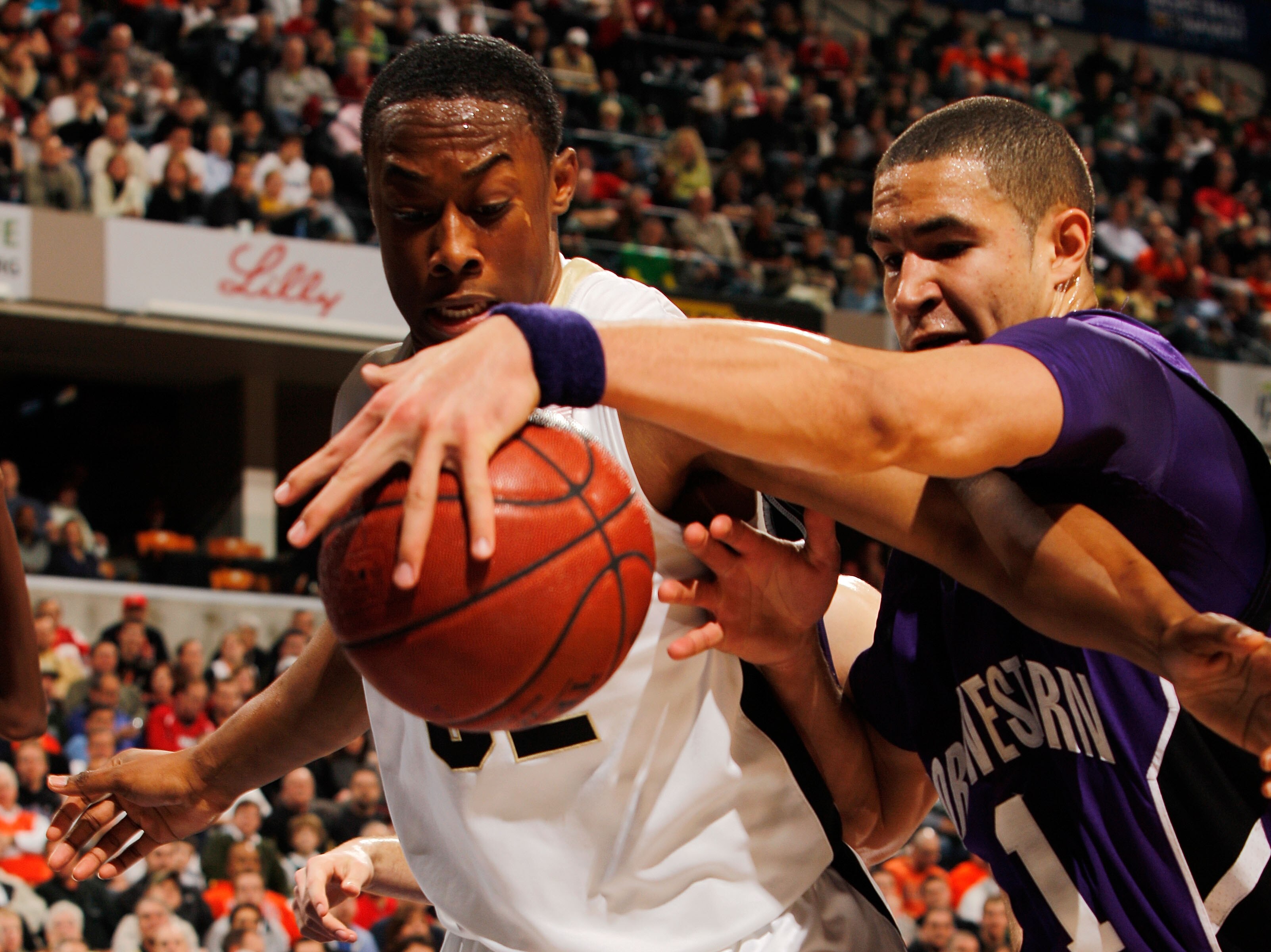 INDIANAPOLIS - MARCH 12:  Forward Drew Crawford #1 of the Northwestern Wildcats trys to keep the ball in bounds against guard John Hart #32 of the Purdue Boilermakers during their quarterfinal game in the Big Ten Men's Basketball Tournament at Conseco Fie