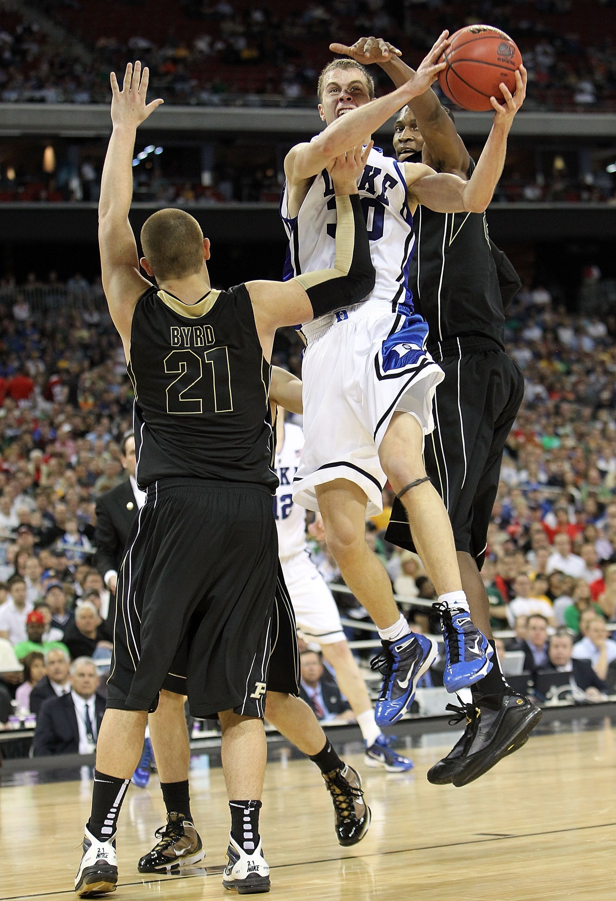 HOUSTON - MARCH 26:  Guard Jon Scheyer #30 of the Duke Blue Devils takes a shot against D.J. Byrd of the Purdue Boilermakers during the south regional semifinal of the 2010 NCAA men's basketball tournament at Reliant Stadium on March 26, 2010 in Houston,