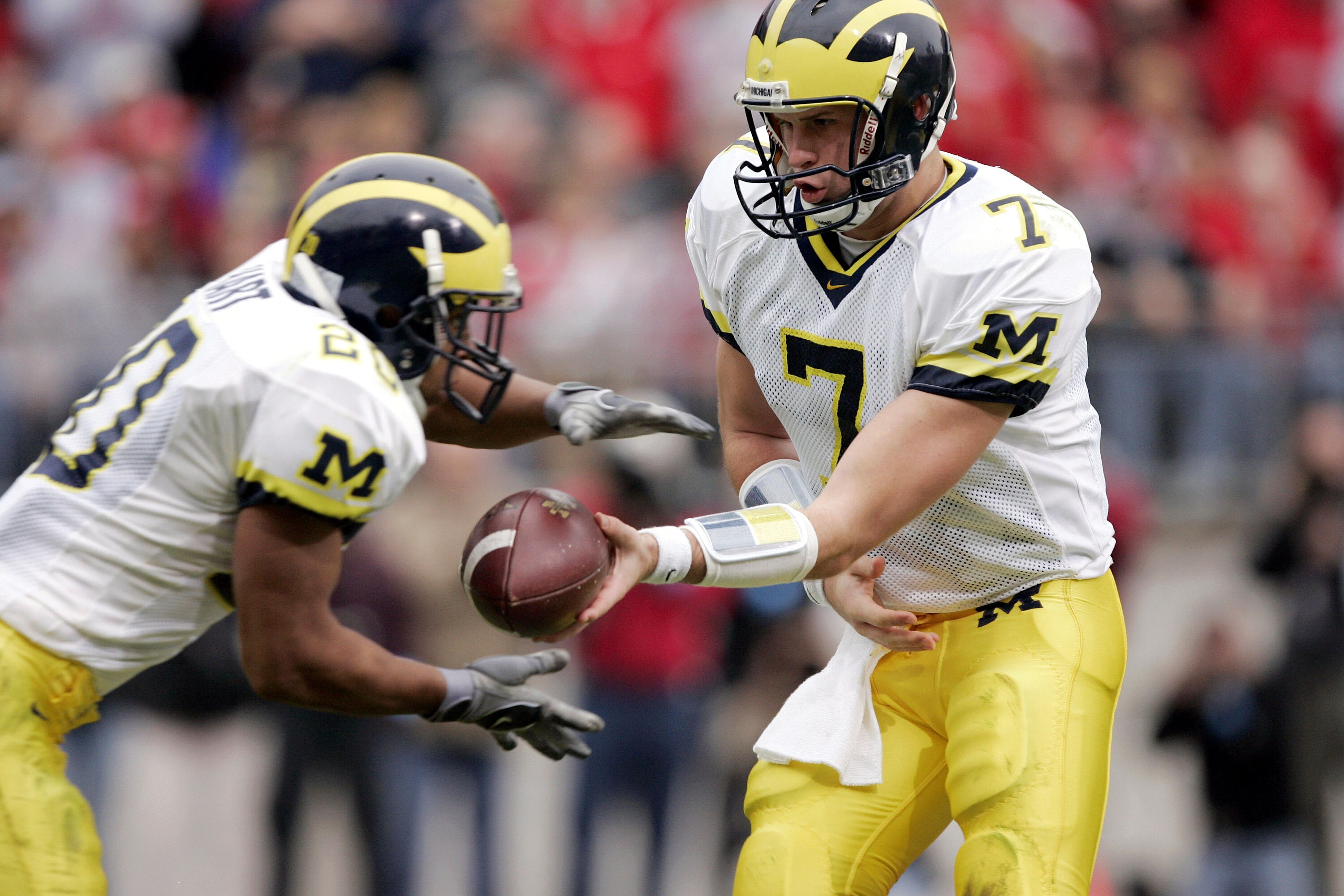 COLUMBUS, OH - NOVEMBER 20:  Quarterback Chad Henne #7 of the Michigan Wolverines hands off to running back Mike Hart #20 against the Ohio State Buckeyes during the second quarter on November 20, 2004 at Ohio Stadium in Columbus, Ohio.  Ohio State upset M