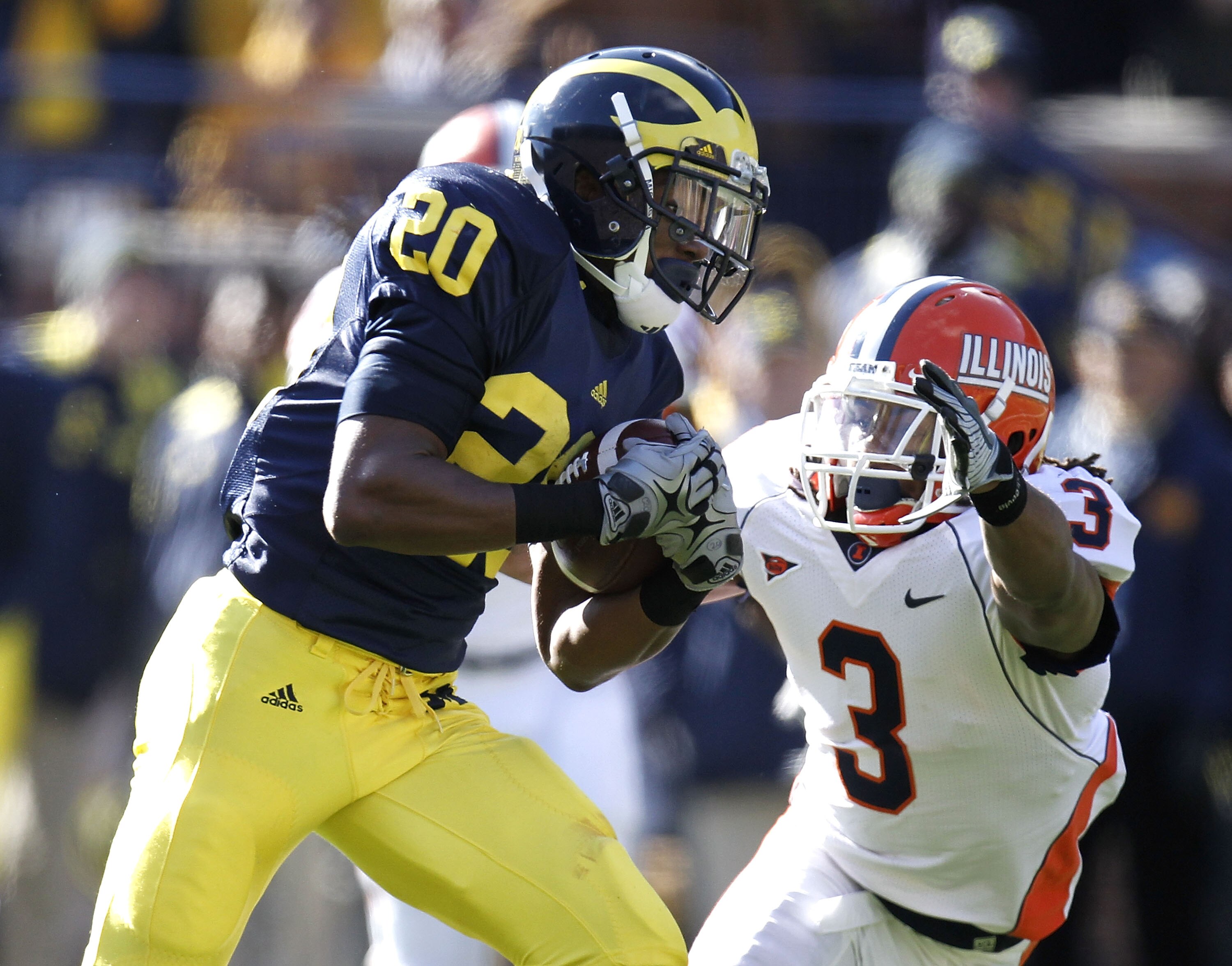 ANN ARBOR, MI - NOVEMBER 06:  Michael Shaw #20 of the Michigan Wolverines runs for a third quarter touchdown around the tackle of Tavon Wilson #3 of the Illinios Fighting Illini at Michigan Stadium on November 6, 2010 in Ann Arbor, Michigan. Michigan won