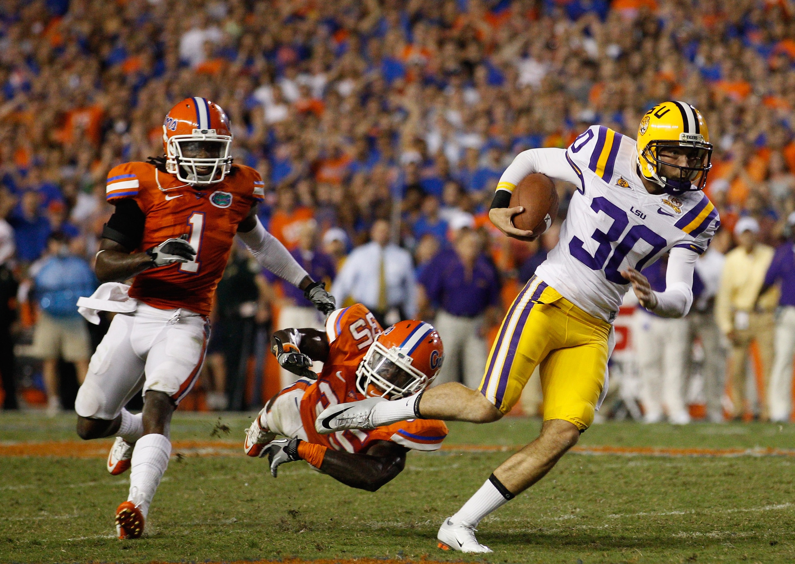 GAINESVILLE, FL - OCTOBER 09: Punter Josh Jasper #30 of the Louisiana State Tigers runs a fake punt for yardage past Ahmad Black #35 and Janoris Jenkins #1 of the Florida Gators during the game at Ben Hill Griffin Stadium on October 9, 2010 in Gainesvill GAINESVILLE, FL - OCTOBER 09: Punter Josh Jasper #30 of the Louisiana State Tigers runs a fake punt for yardage past Ahmad Black #35 and Janoris Jenkins #1 of the Florida Gators during the game at Ben Hill Griffin Stadium on October 9, 2010 in Gainesvill