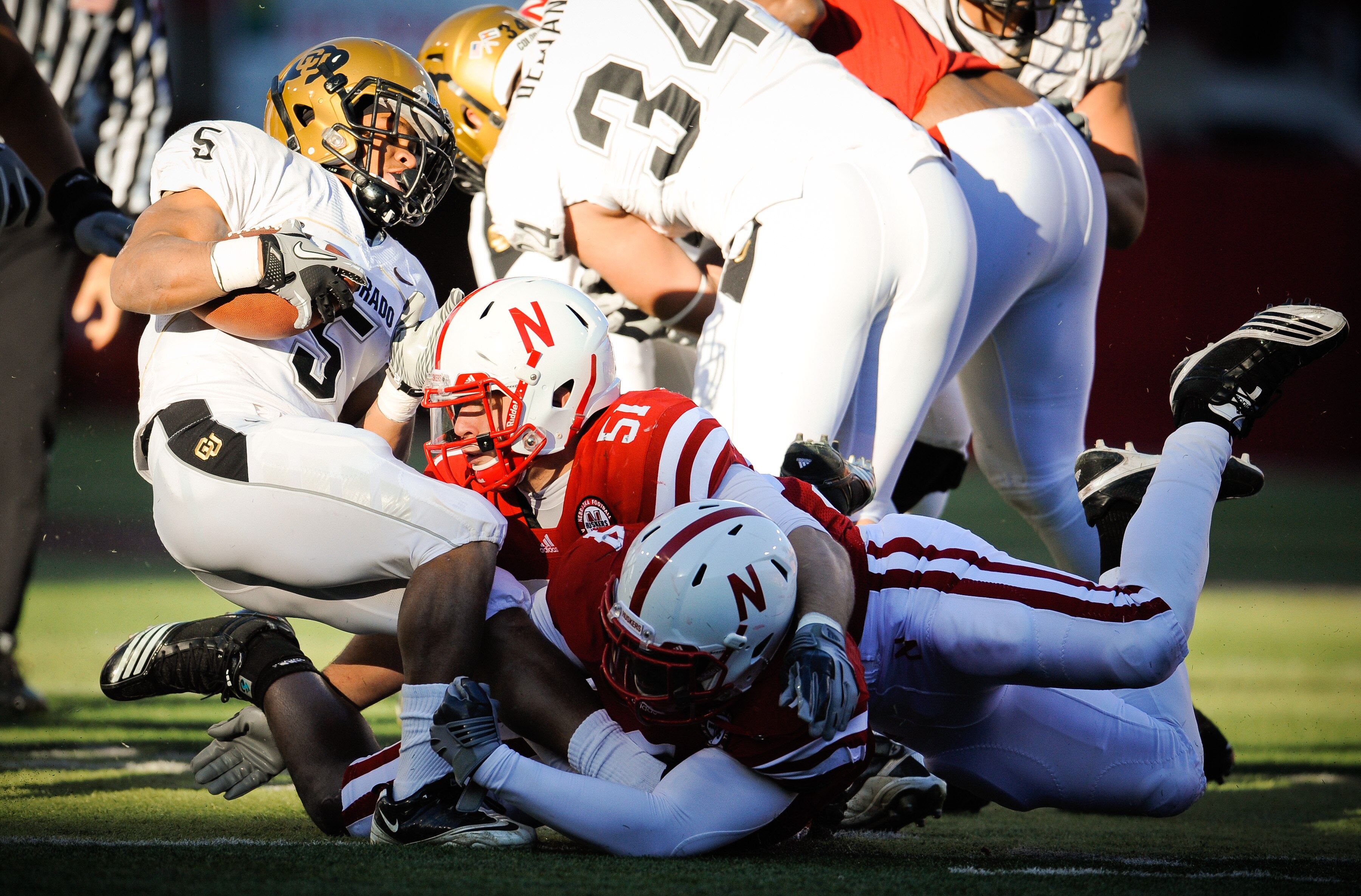 LINCOLN, NE - NOVEMBER 26: Lavonte David #4 and Will Compton #51 of the Nebraska Cornhuskers bring down Rodney Stewart #5 of the Colorado Buffaloes during the first half of their game at Memorial Stadium on November 26, 2010 in Lincoln, Nebraska.  (Photo