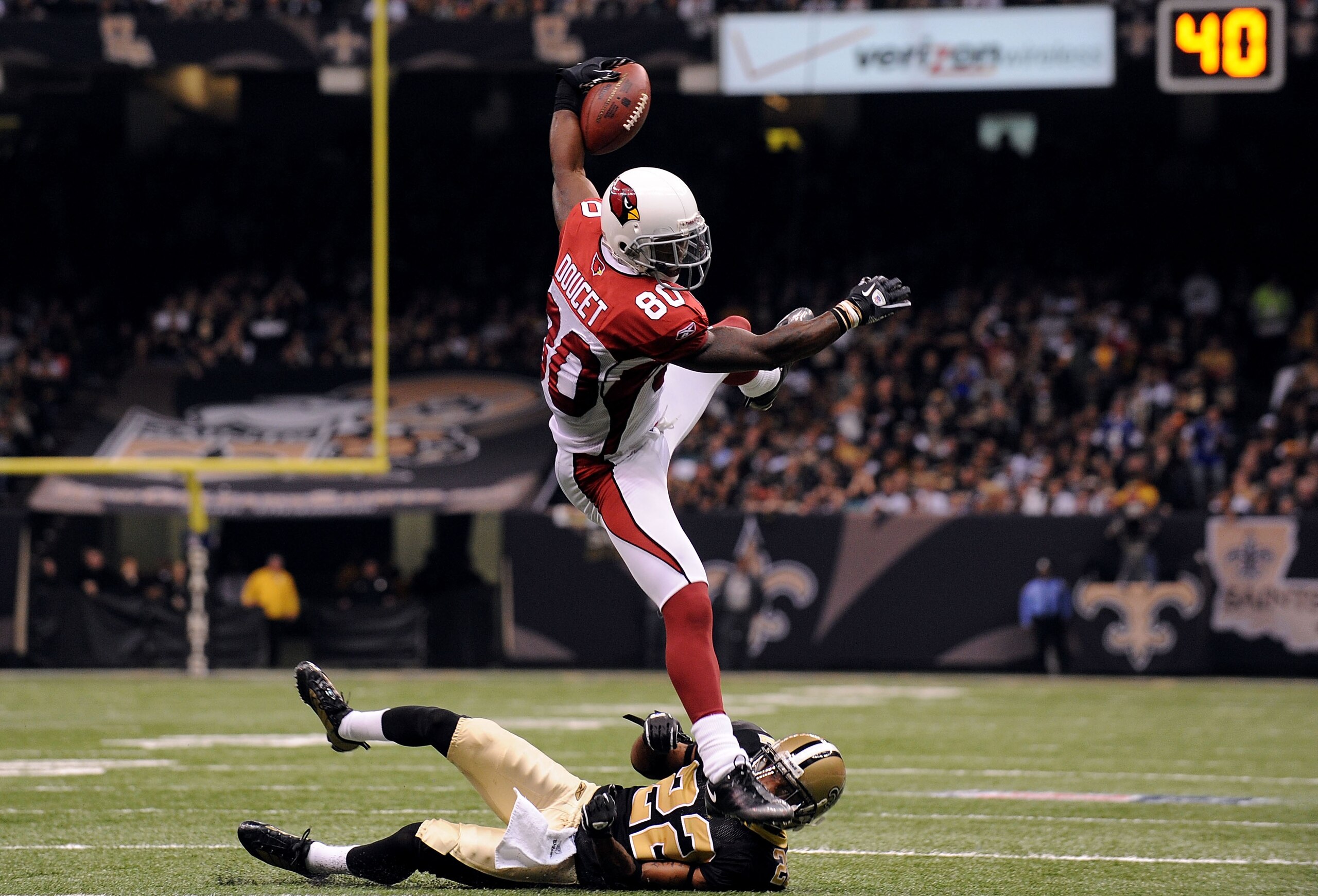 NEW ORLEANS - JANUARY 16: Early Doucet #80 of the Arizona Cardinals takes the ball down to the 5 yard line on a reception in the first half against Tracy Porter #22 of the New Orleans Saints during the NFC Divisional Playoff Game at Louisana Superdome on NEW ORLEANS - JANUARY 16: Early Doucet #80 of the Arizona Cardinals takes the ball down to the 5 yard line on a reception in the first half against Tracy Porter #22 of the New Orleans Saints during the NFC Divisional Playoff Game at Louisana Superdome on