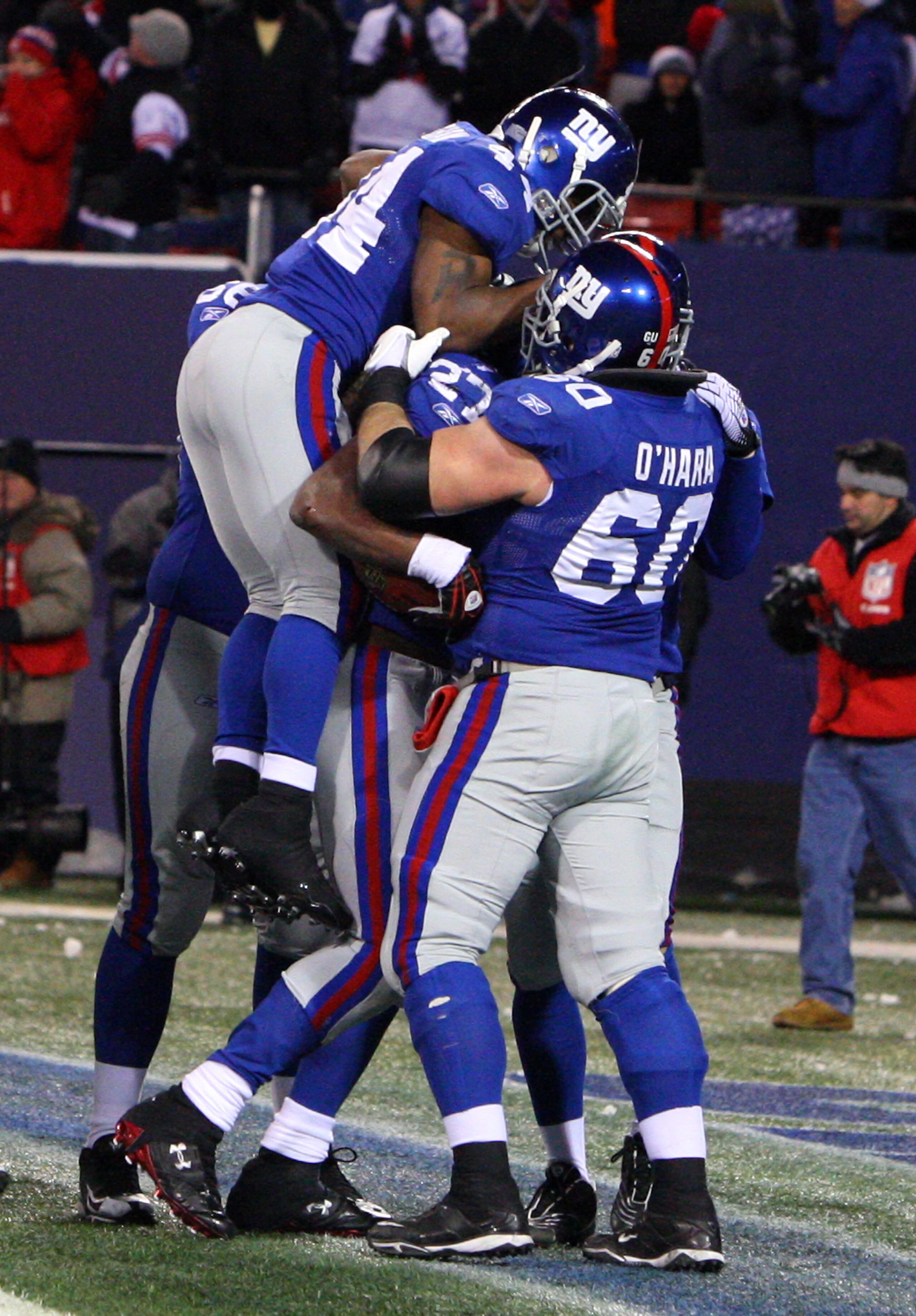EAST RUTHERFORD, NJ - DECEMBER 21:  Running back Brandon Jacobs #27 of the New York Giants celebrates with teammates Derrick Ward #34 and Shaun O'Hara #60 in the end zone after scoring a touchdown against the Carolina Panthers in over time on December 21,