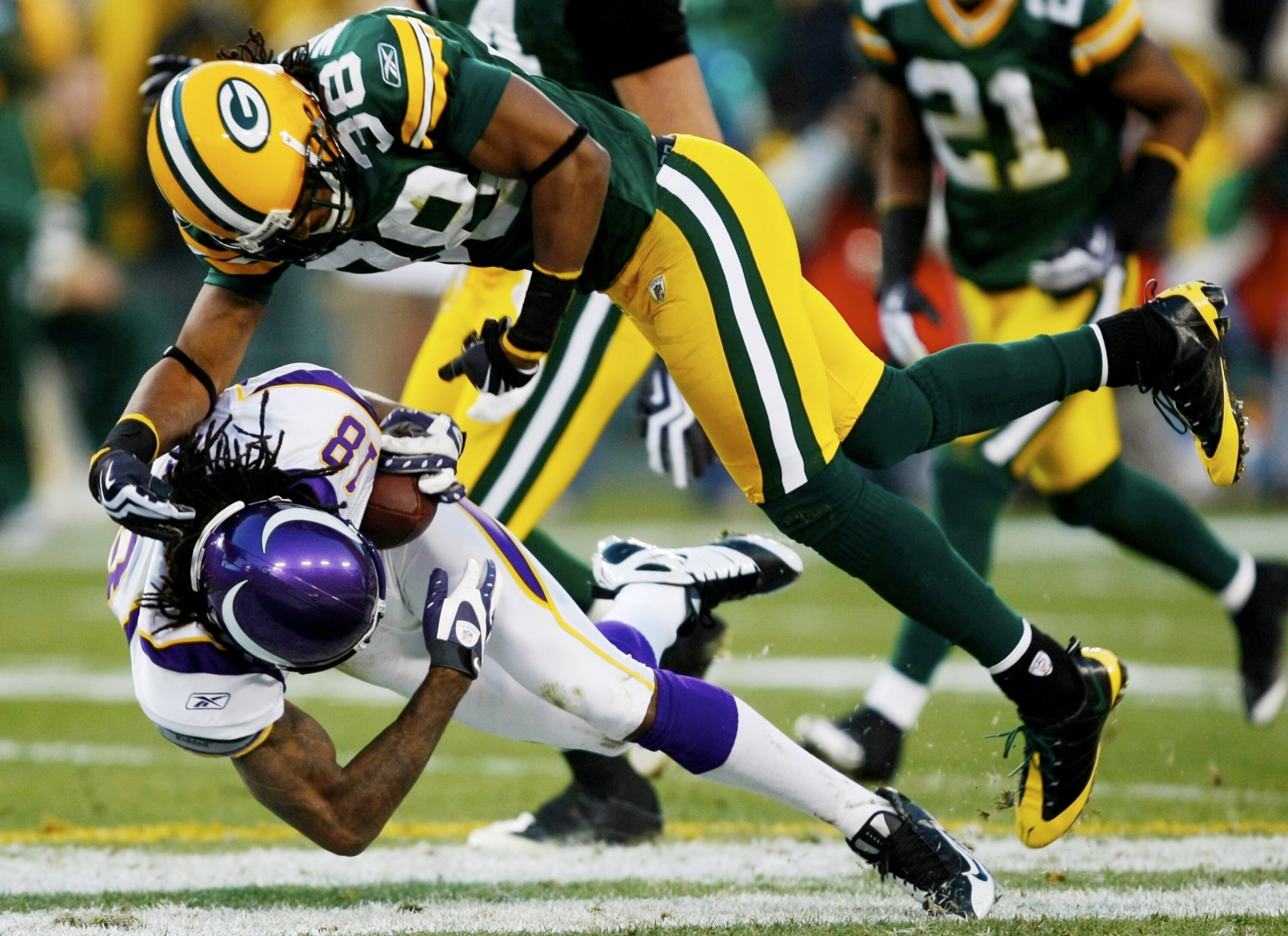 GREEN BAY, WI - NOVEMBER 01:  Tramon Williams #38 of the Green Bay Packers leaps over Sidney Rice #18 of the Minnesota Vikings during the second quarter of the game at Lambeau Field on November 1, 2009 in Green Bay, Wisconsin. (Photo by Scott Boehm/Getty