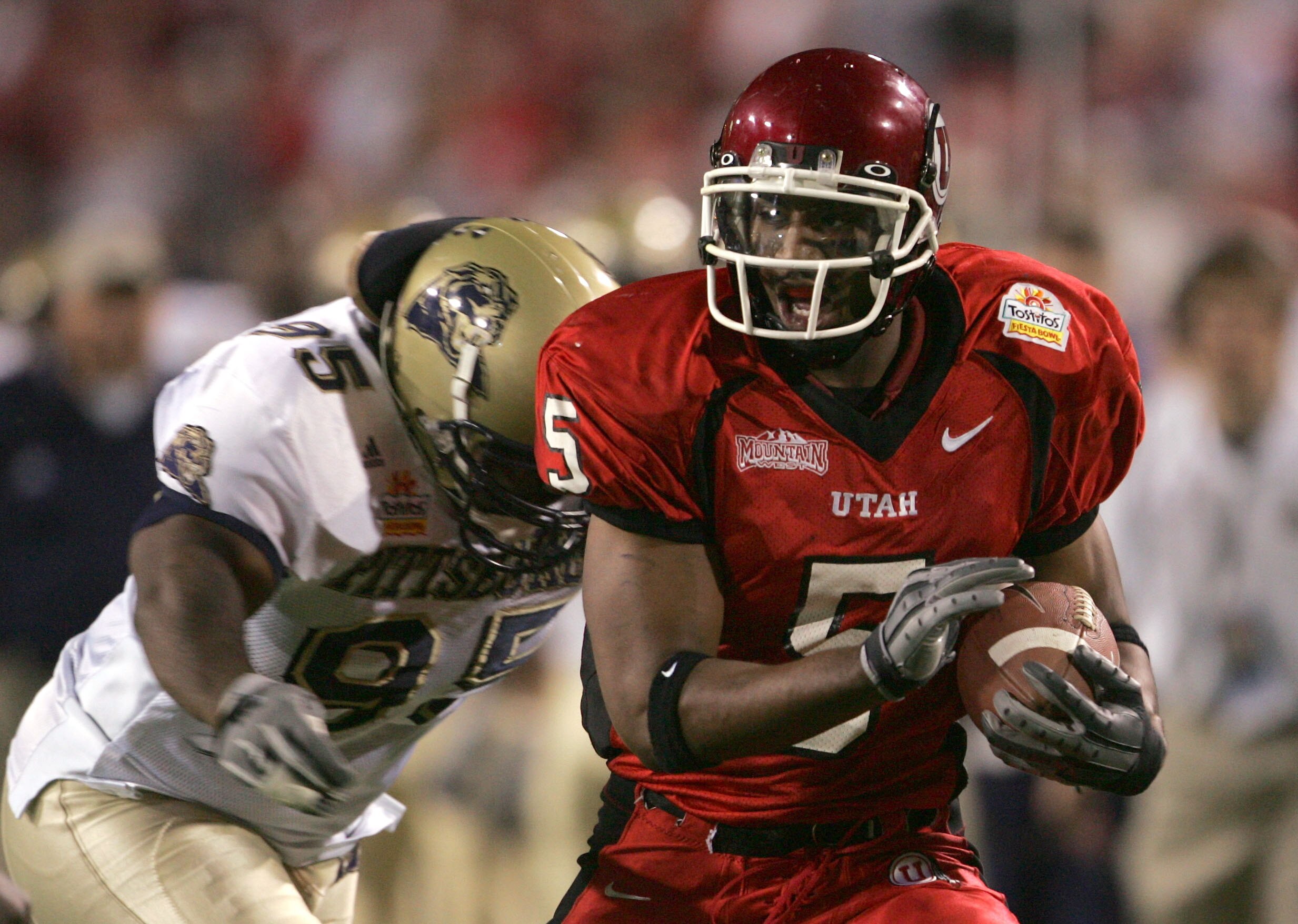 TEMPE, AZ - JANUARY 1:  Paris Warren #5 of Utah runs past Keith Hill #95 of Pittsburgh in the Tostito's Fiesta Bowl at the Sun Devil Stadium on January 1, 2005 in Tempe, Arizona. (Photo by Jeff Gross/Getty Images).