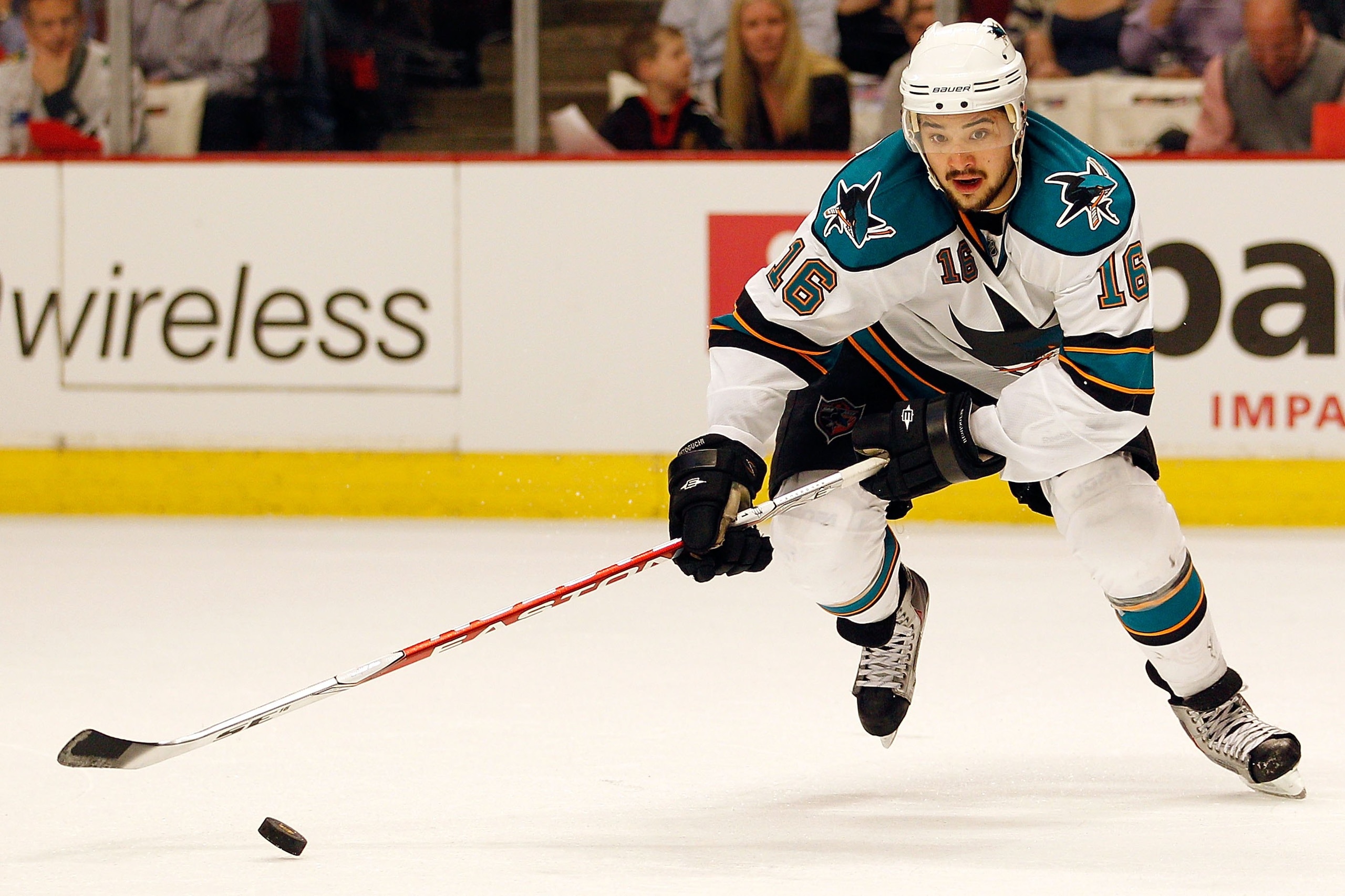 CHICAGO - MAY 21:  Devin Setoguchi #16 of the San Jose Sharks moves the puck while taking on the Chicago Blackhawks in Game Three of the Western Conference Finals during the 2010 NHL Stanley Cup Playoffs at the United Center on May 21, 2010 in Chicago, Il