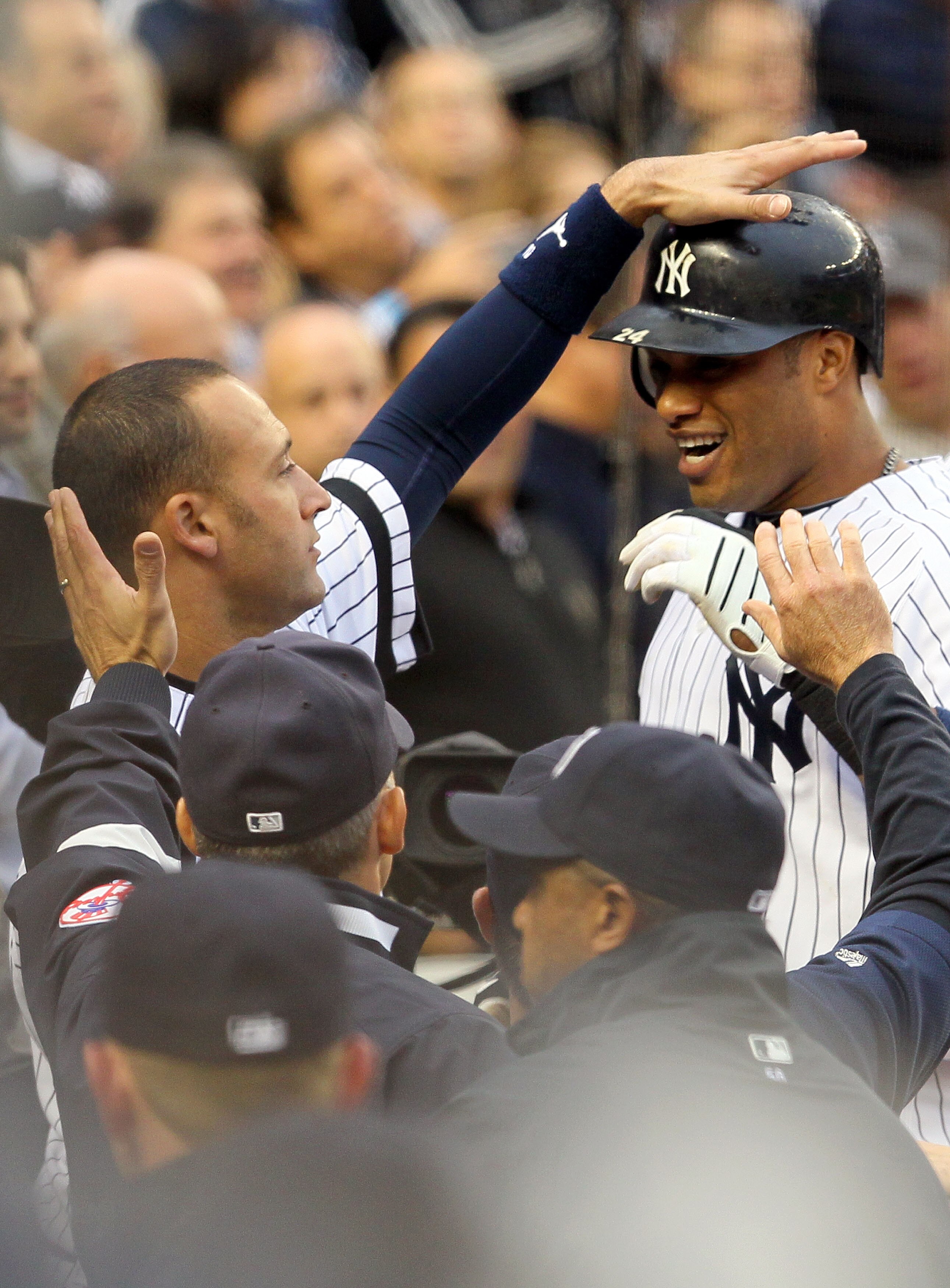 NEW YORK - OCTOBER 20:  Robinson Cano #24 and Derek Jeter #2 (L) of the New York Yankees celebrate in the dugout after Cano hit a solo home run in the third inning against the Texas Rangers in Game Five of the ALCS during the 2010 MLB Playoffs at Yankee S