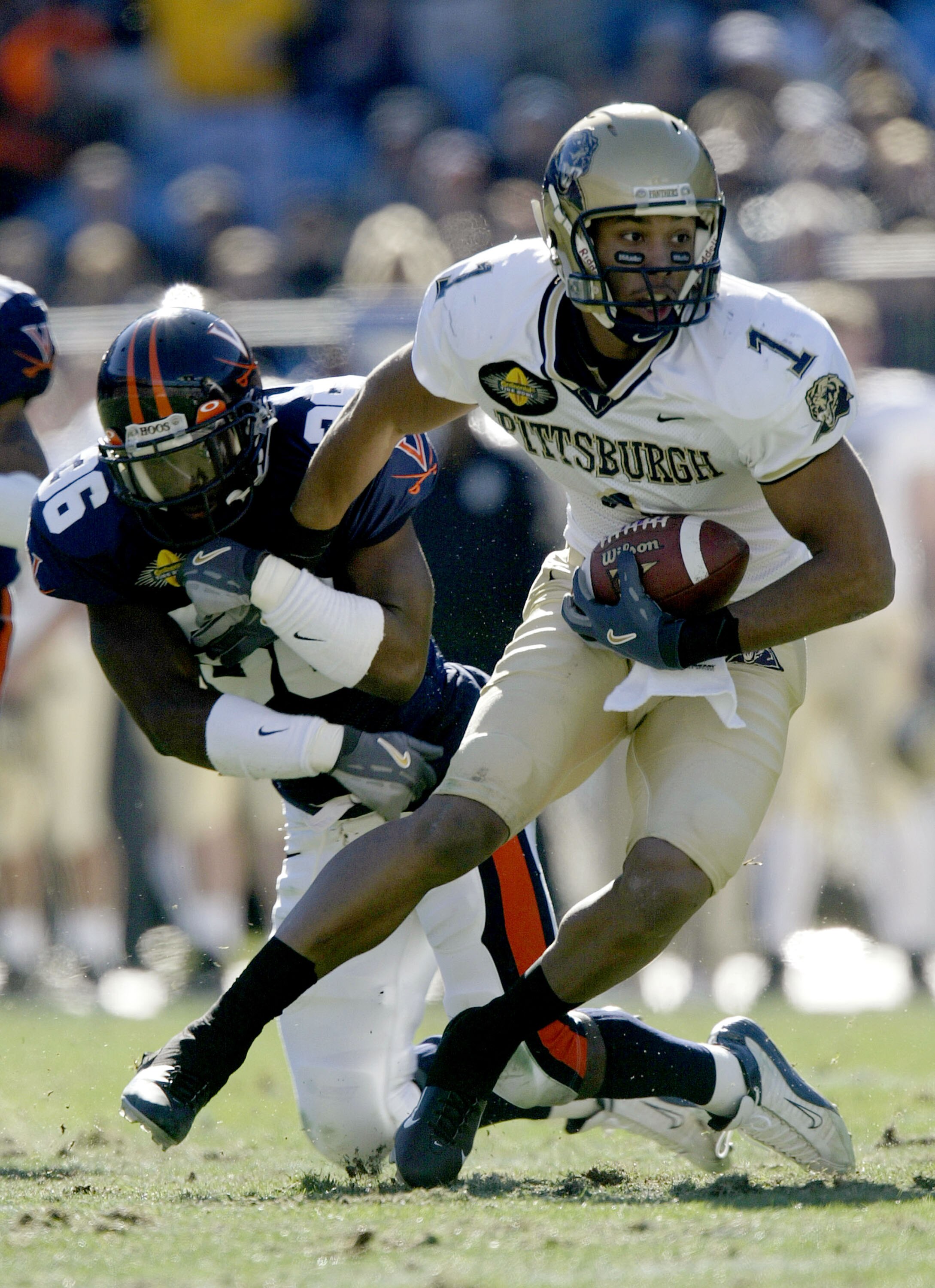 CHARLOTTE, NC - DECEMBER 27:  Larry Fitzgerald #1 of the Pittsburgh Panthers runs by Jermaine Hardy #36 of the Virginia Cavaliers during the Continental Tire Bowl December 27, 2003 at Ericsson Stadium in Charlotte, North Carolina.  (Photo by Craig Jones/G