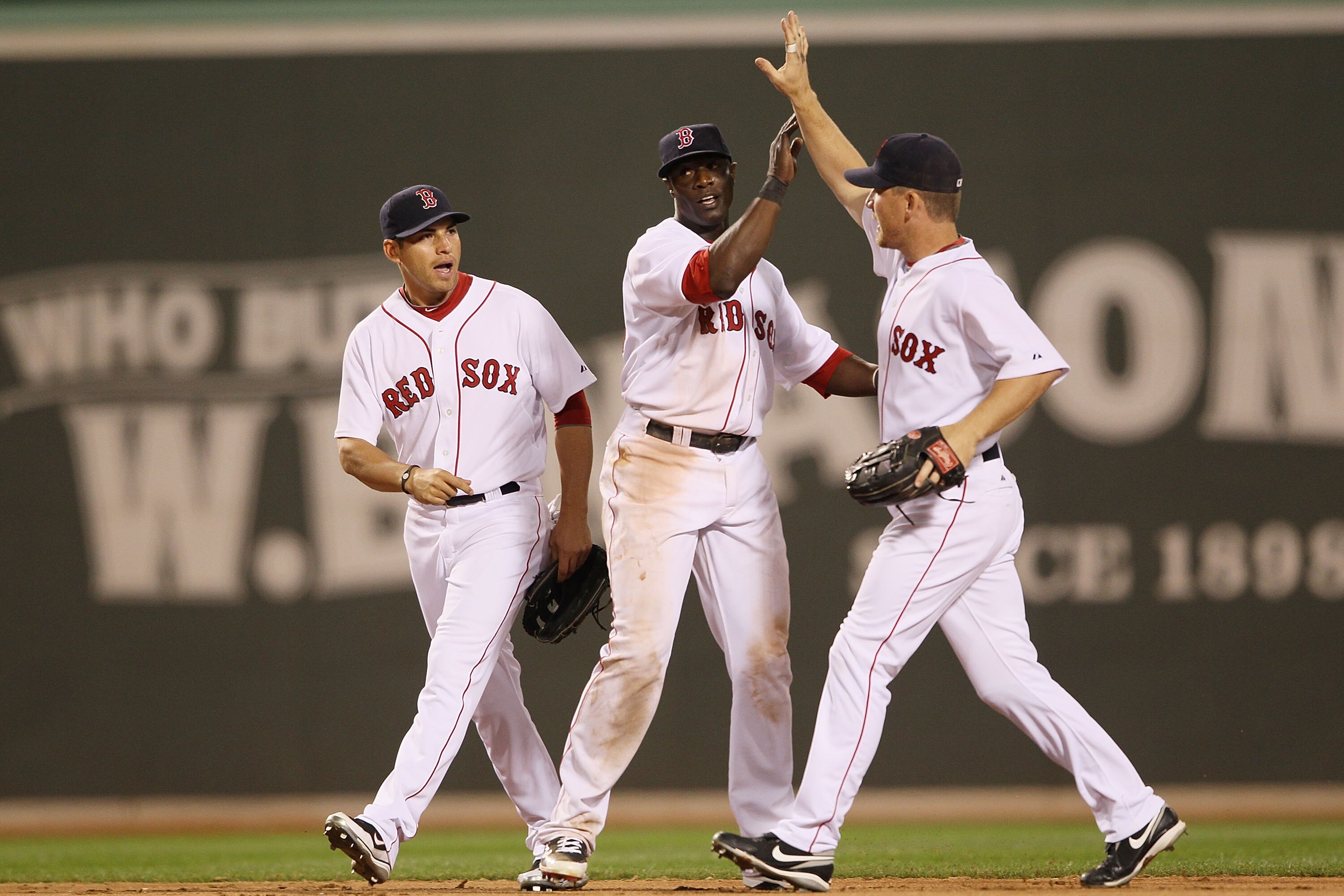 BOSTON - APRIL 04:  Jacoby Ellsbury #2,Mike Cameron #23 and J.D. Drew #7 of the Boston Red Sox celebrate the win over the New York Yankees on April 4, 2010 during Opening Night at Fenway Park in Boston, Massachusetts. The Red Sox defeated the Yankees 9-7.