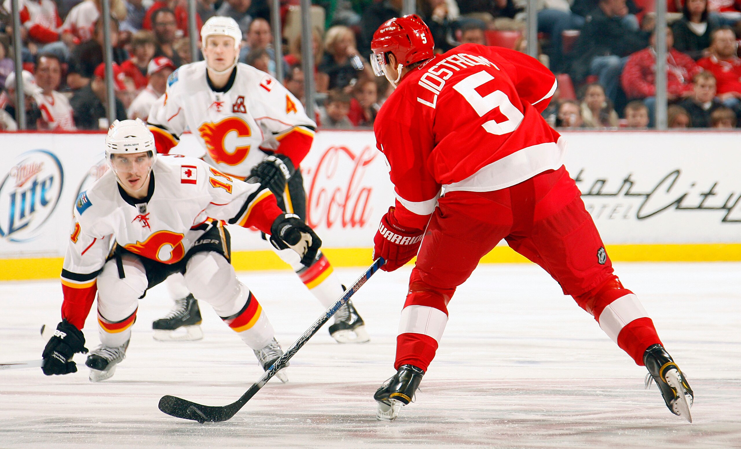 DETROIT - NOVEMBER 21:  Mikael Backlund #11 and Jay Bouwmeester #4 both of the Calgary Flames defend against Nicklas Lidstrom #5 of the Detroit Red Wings during their NHL game at Joe Louis Arena on November 21, 2010 in Detroit, Michigan.(Photo By Dave San