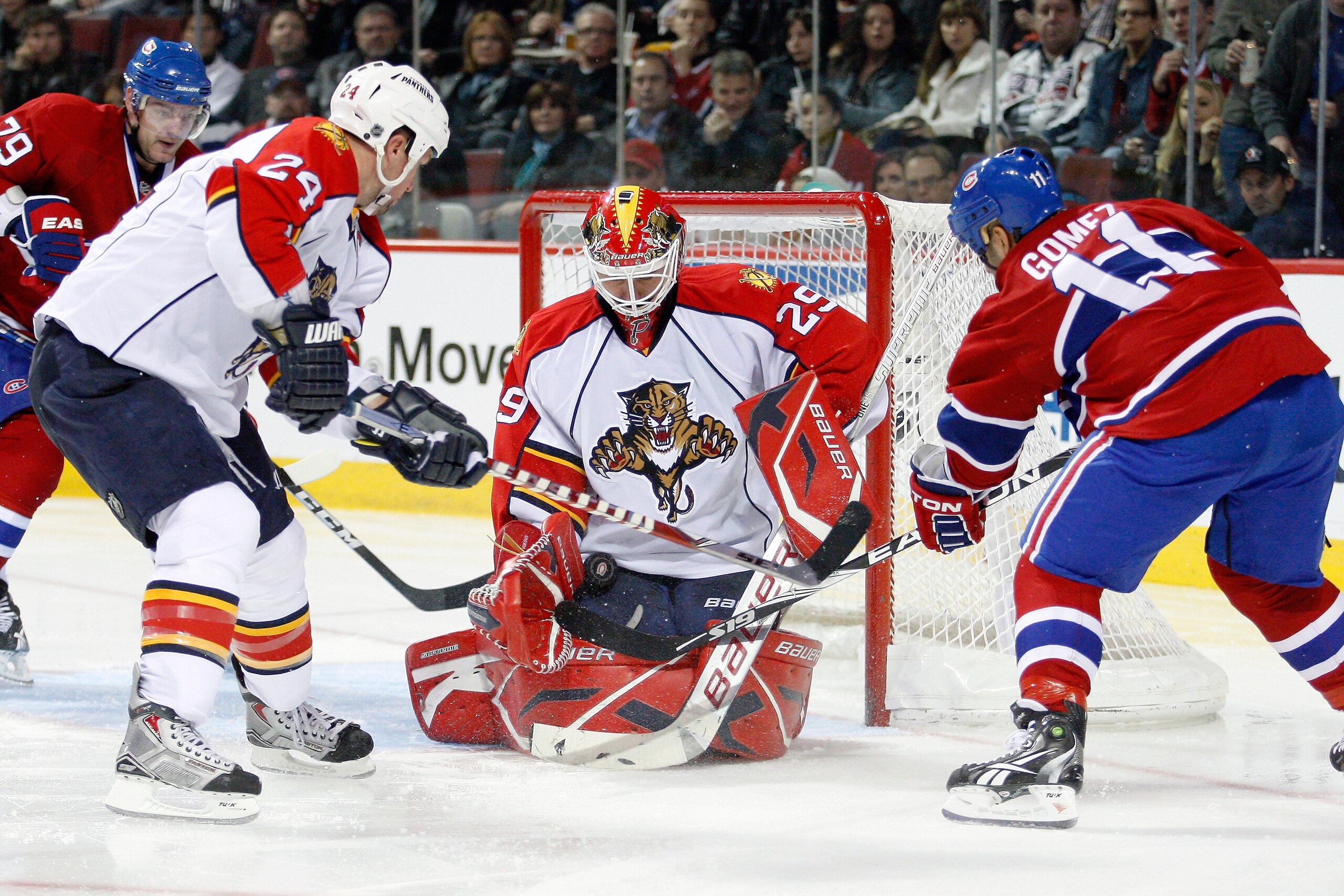 MONTREAL- OCTOBER 30:  Tomas Vokoun #29 of the Florida Panthers stops the puck in front of team mate Bryan McCabe #24 and Scott Gomez #11 of the Montreal Canadiens during the NHL game at the Bell Centre on October 30, 2010 in Montreal, Quebec, Canada.  (P