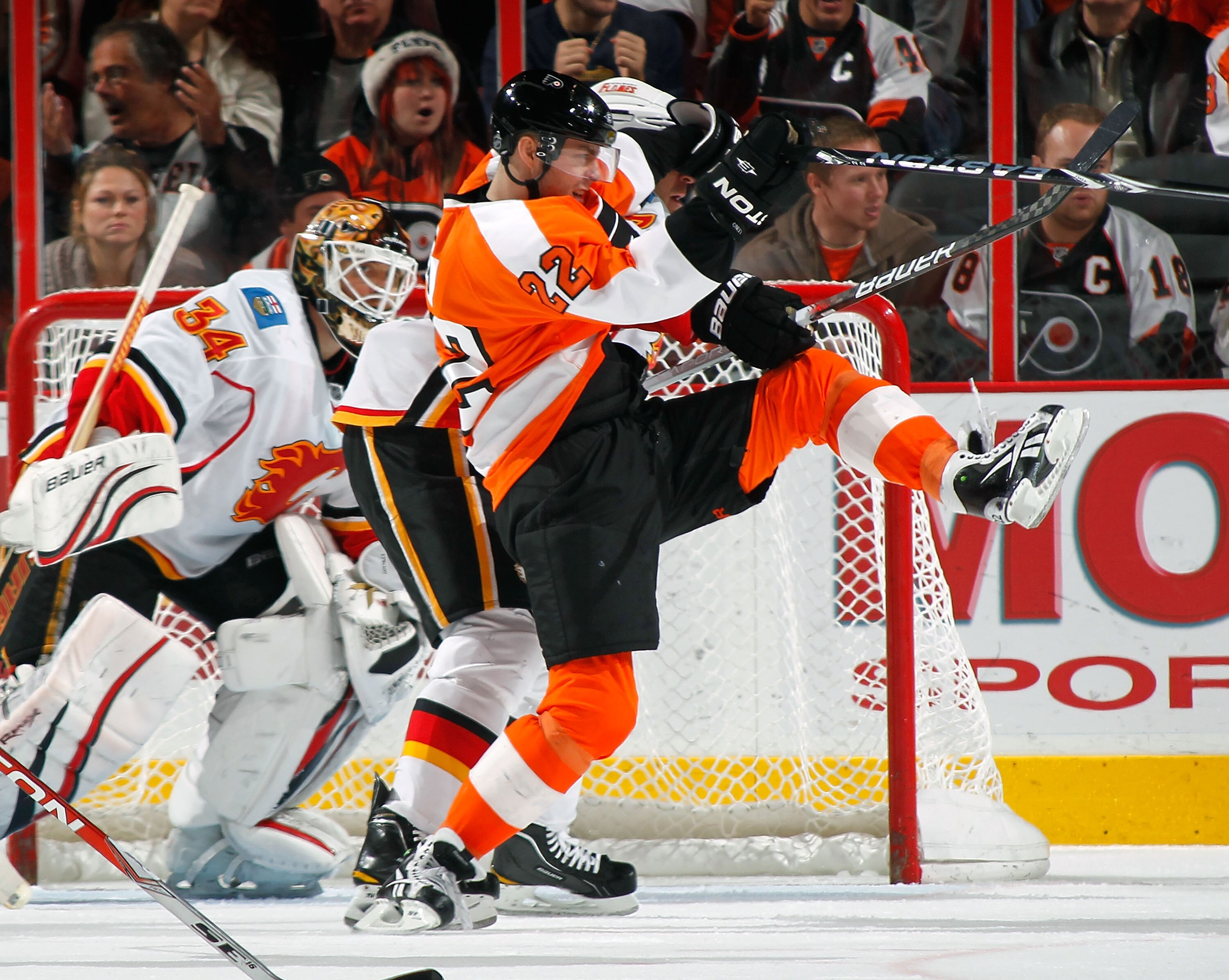 PHILADELPHIA - NOVEMBER 26:  Ville Leino #22 of the Philadelphia Flyers loses his footing as he battles for position in front of the goal as goalie Miikka Kiprusoff #34 moves across the goal during the third period of a hockey game at the Wells Fargo Cent