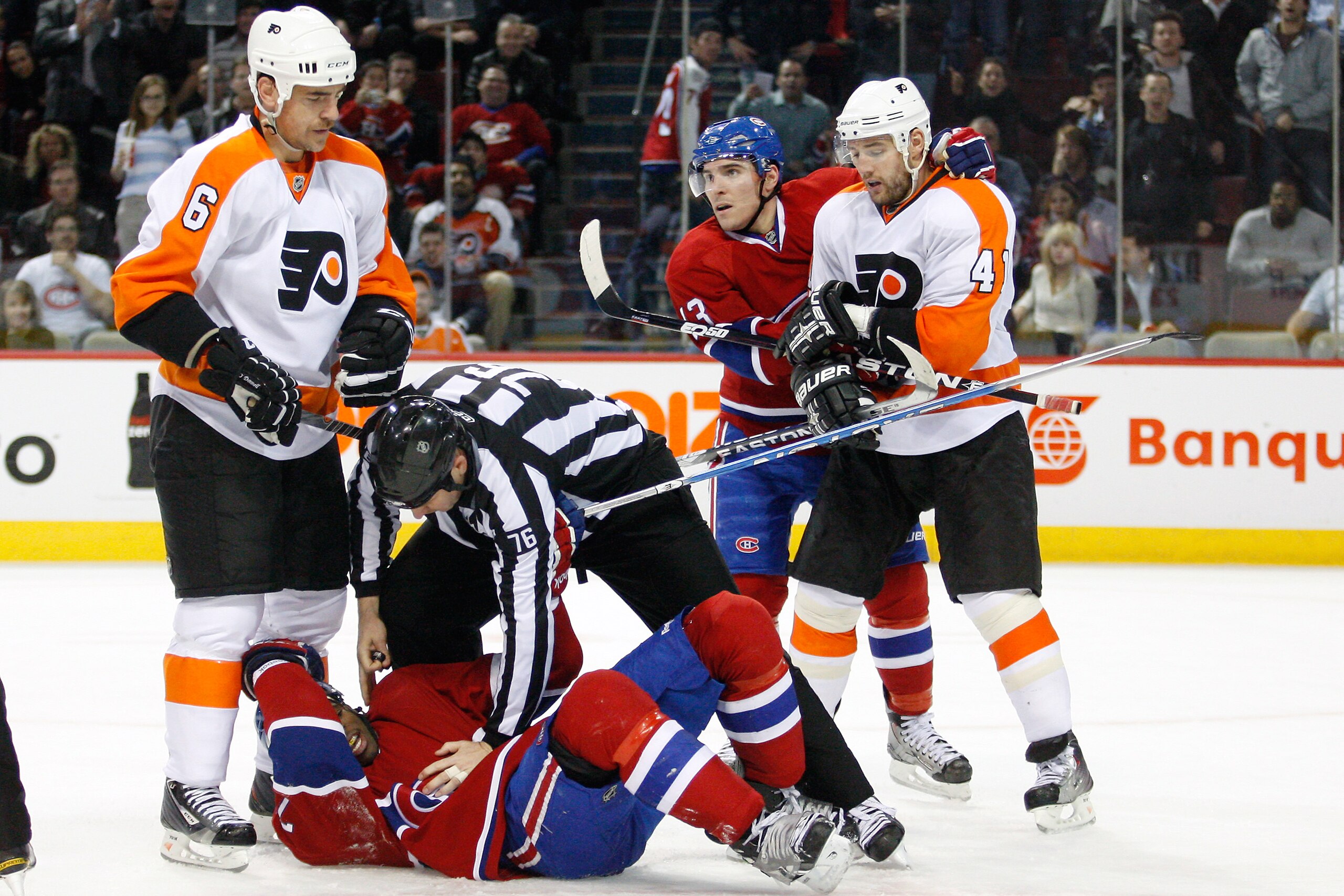 MONTREAL - NOVEMBER 16:  NHL linesman Michel Cormier (76) helps up P.K. Subban #76 of the Montreal Canadiens after being knocked to the ice by Sean O'Donnell #6 of the Philadelphia Flyers during the NHL game at the Bell Centre on November 16, 2010 in Mont