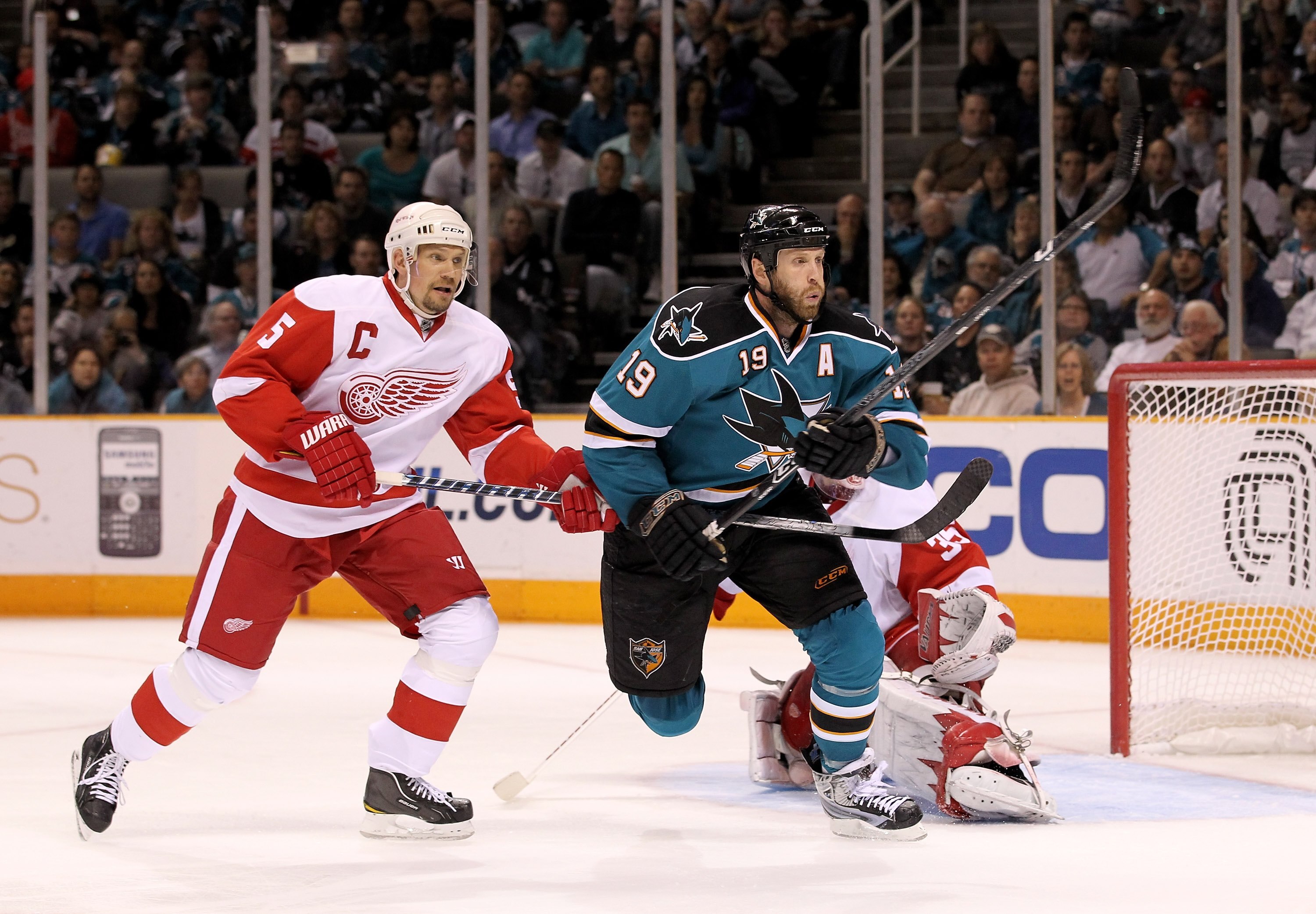 SAN JOSE, CA - MAY 02:  Joe Thornton #19 of the San Jose Sharks races after the puck while defended by Nicklas Lidstrom #5 and Jimmy Howard #35 plays in the goal for the Detroit Red Wings in Game Two of the Western Conference Semifinals during the 2010 NH