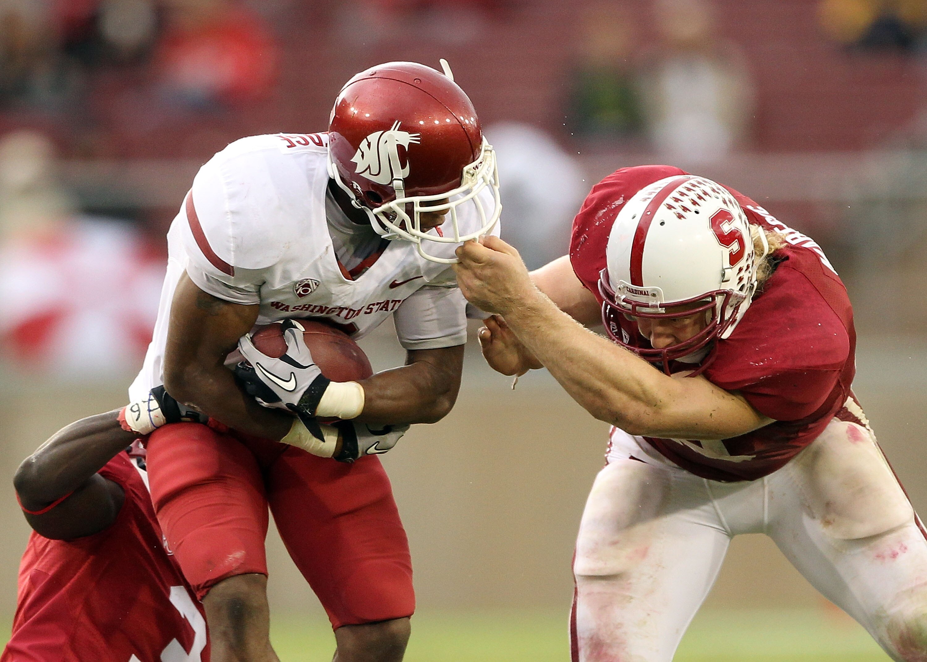 PALO ALTO, CA - OCTOBER 23:  Owen Marecic #48 of the Stanford Cardinal grabs the fask mask of Daniel Blackledge #2 of the Washington State Cougars at Stanford Stadium on October 23, 2010 in Palo Alto, California.  (Photo by Ezra Shaw/Getty Images)