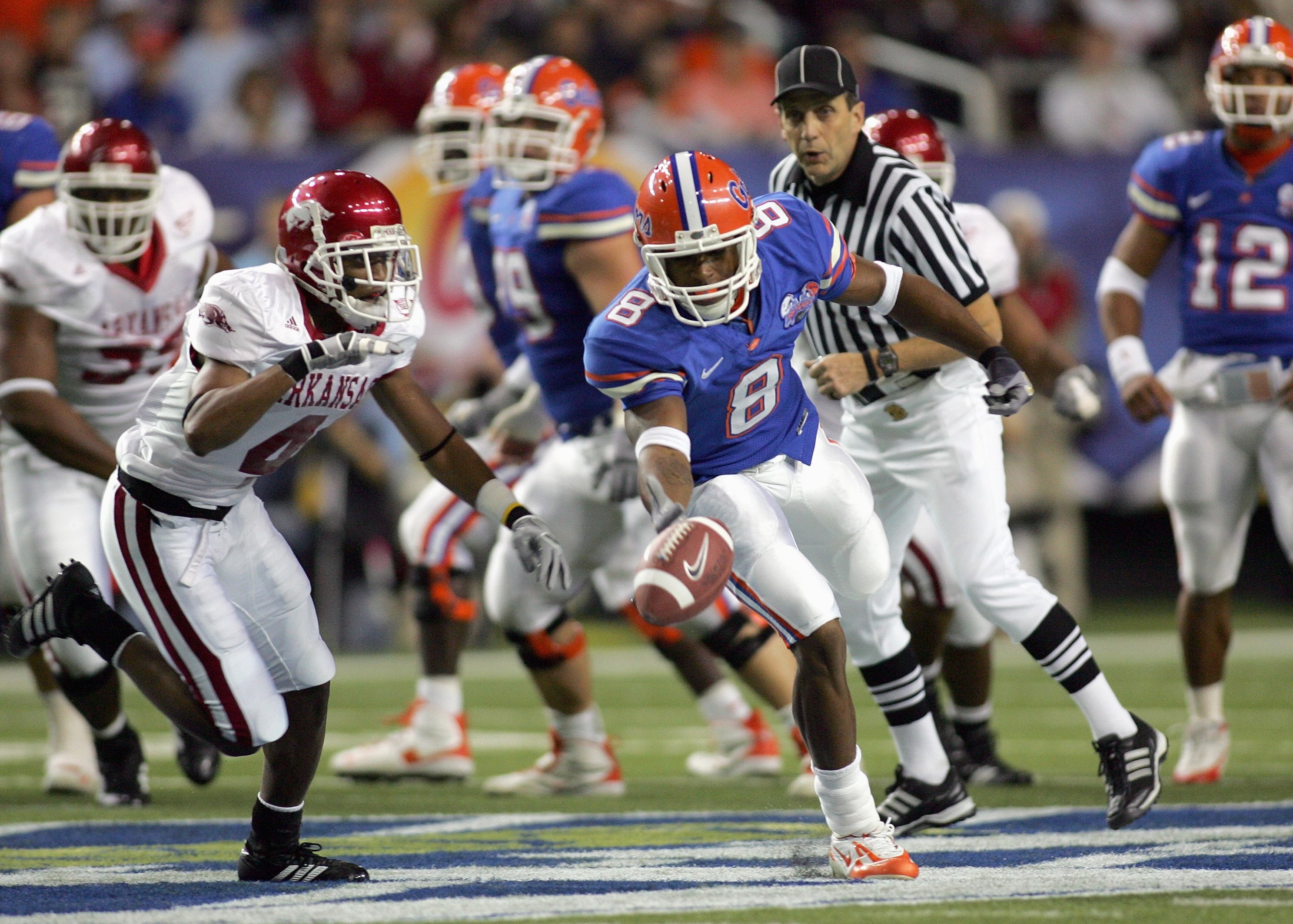 ATLANTA - DECEMBER 2:  Percy Harvin #8 of the Florida Gators fumbles the ball against Darius Vinnett #4 of the Arkansas Razorbacks during the 2006 SEC Championship Game at the Georgia Dome on December 2, 2006 in Atlanta, Georgia. (Photo by Ronald Martinez