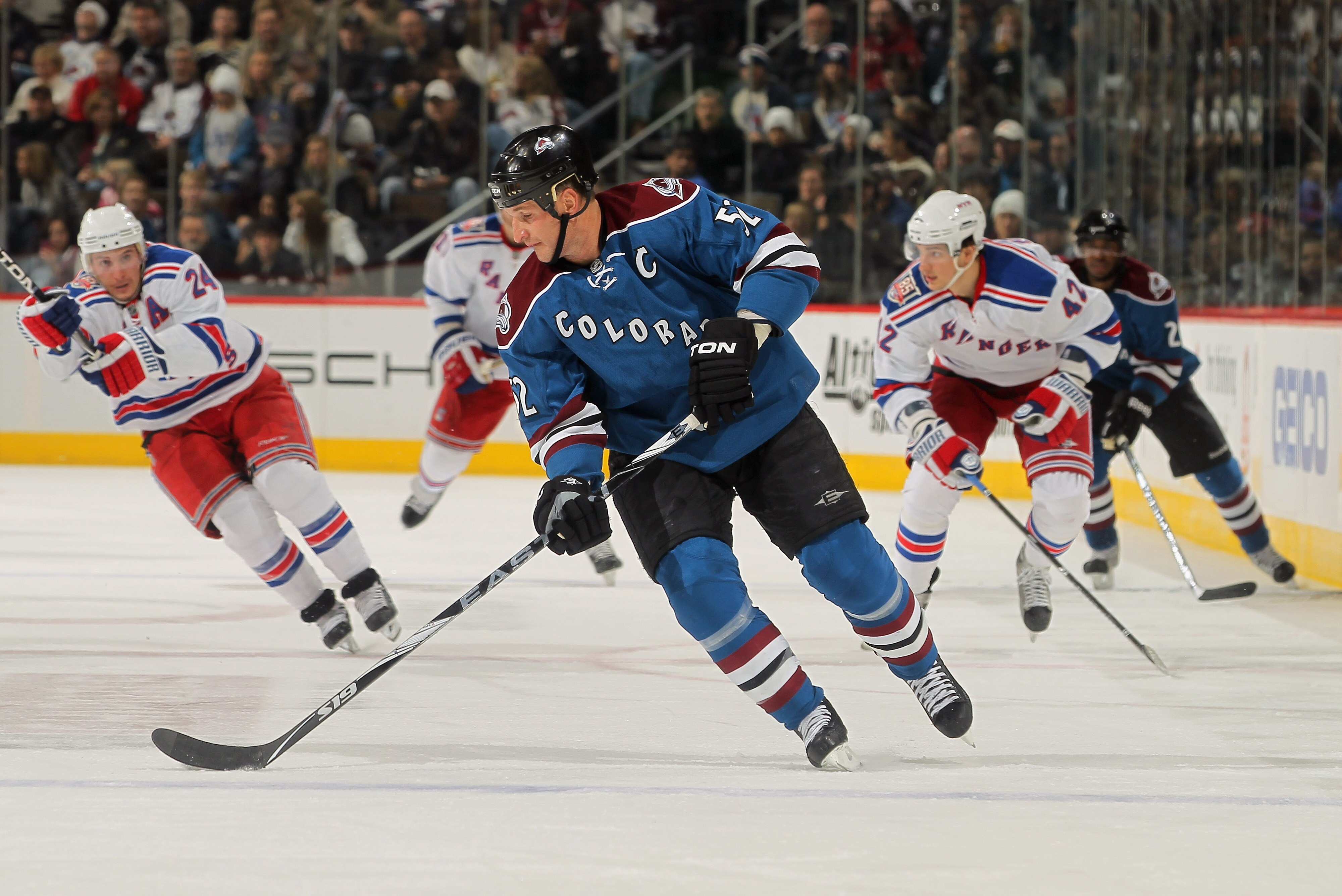 DENVER - NOVEMBER 19:  Adam Foote #52 of the Colorado Avalanche controls the puck against the New York Rangers at the Pepsi Center on November 19, 2010 in Denver, Colorado. The Avalanche defeated the Rangers 5-1.  (Photo by Doug Pensinger/Getty Images)
