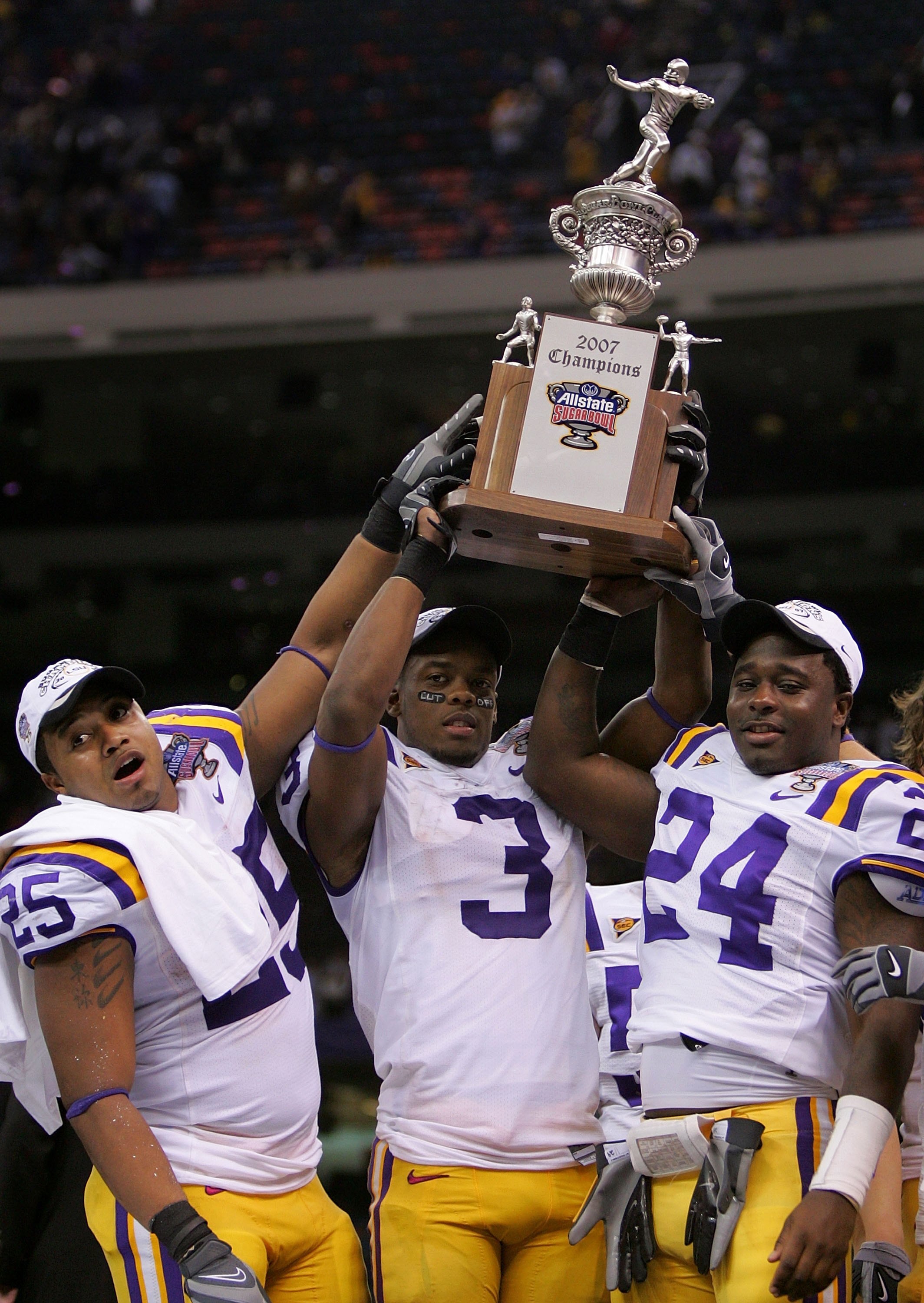 NEW ORLEANS - JANUARY 03:  (L-R) Justin Vincent #25, Buster Davis #3 and Keron Gordon #24 of the LSU Tigers hold up the Championship trophy after their team defeated the Notre Dame Fighting Irish 41-14 in the 2007 Allstate Sugar Bowl on January 3, 2007 at