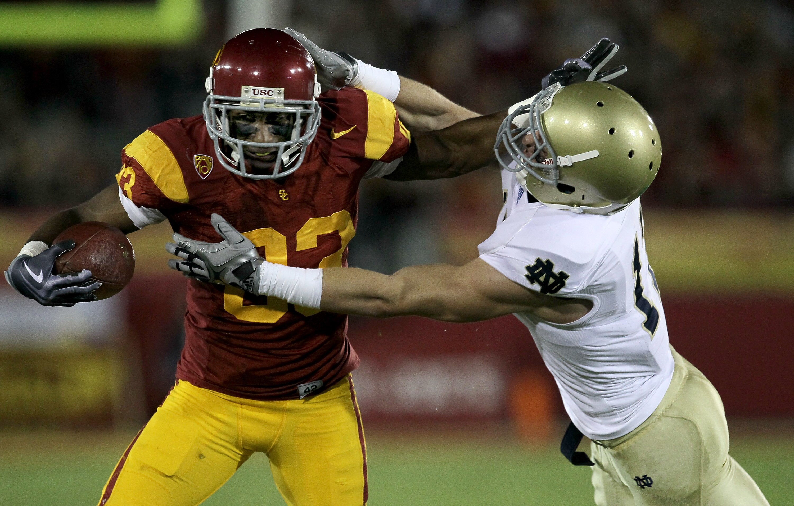 LOS ANGELES - NOVEMBER 27:  Wide receiver Ronald Johnson #83 of the USC Trojans carries ball against safety Zeke Motta #17 of the Notre Dame Fighting Irish at the Los Angeles Memorial Coliseum on November 27, 2010 in Los Angeles, California.   (Photo by S