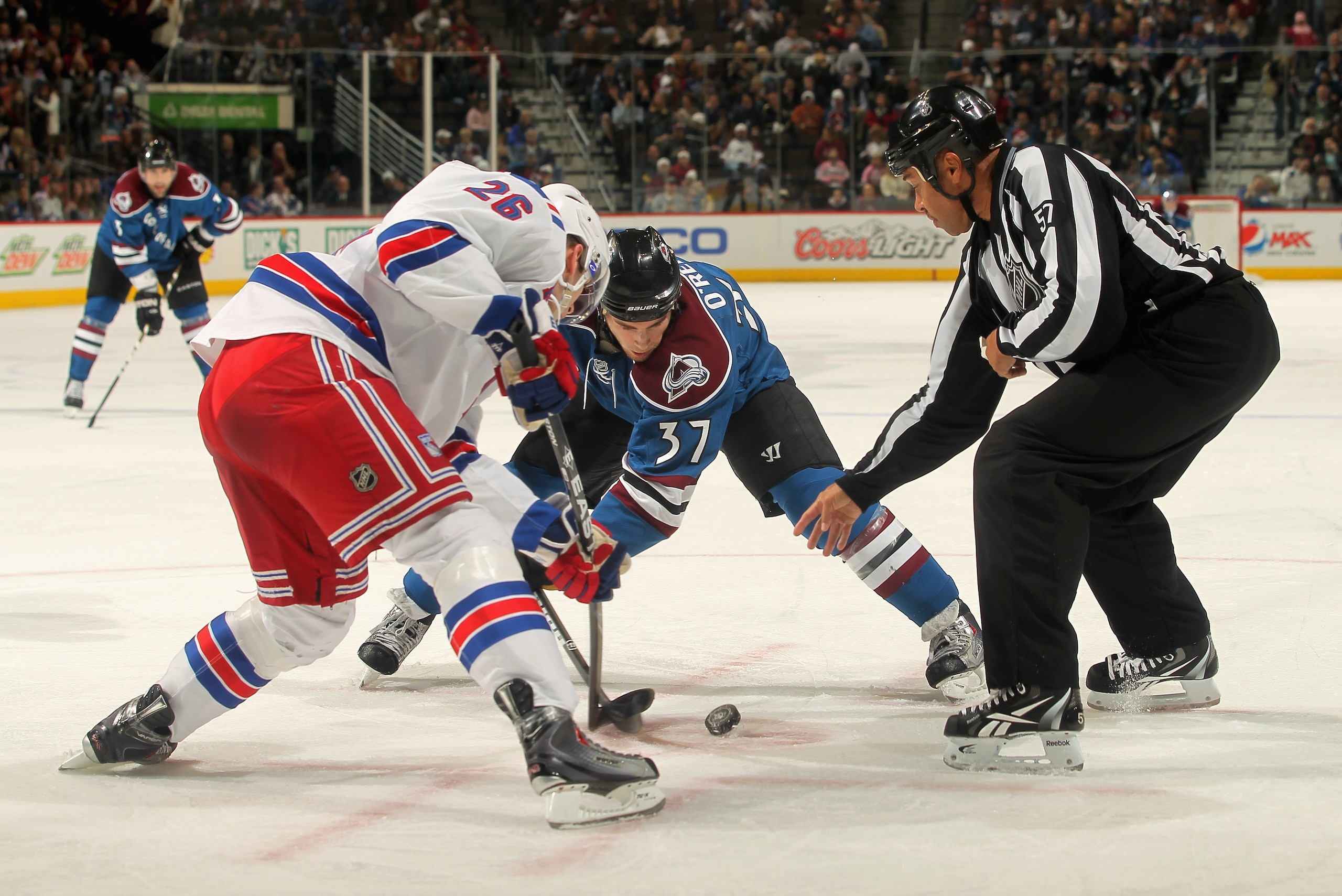DENVER - NOVEMBER 19:  Linesman Jay Sharrers #57 drops the puck for a face off between Erik Christensen #26 of the New York Rangers and Ryan O'Reilly #37 of the Colorado Avalanche at the Pepsi Center on November 19, 2010 in Denver, Colorado. The Avalanche
