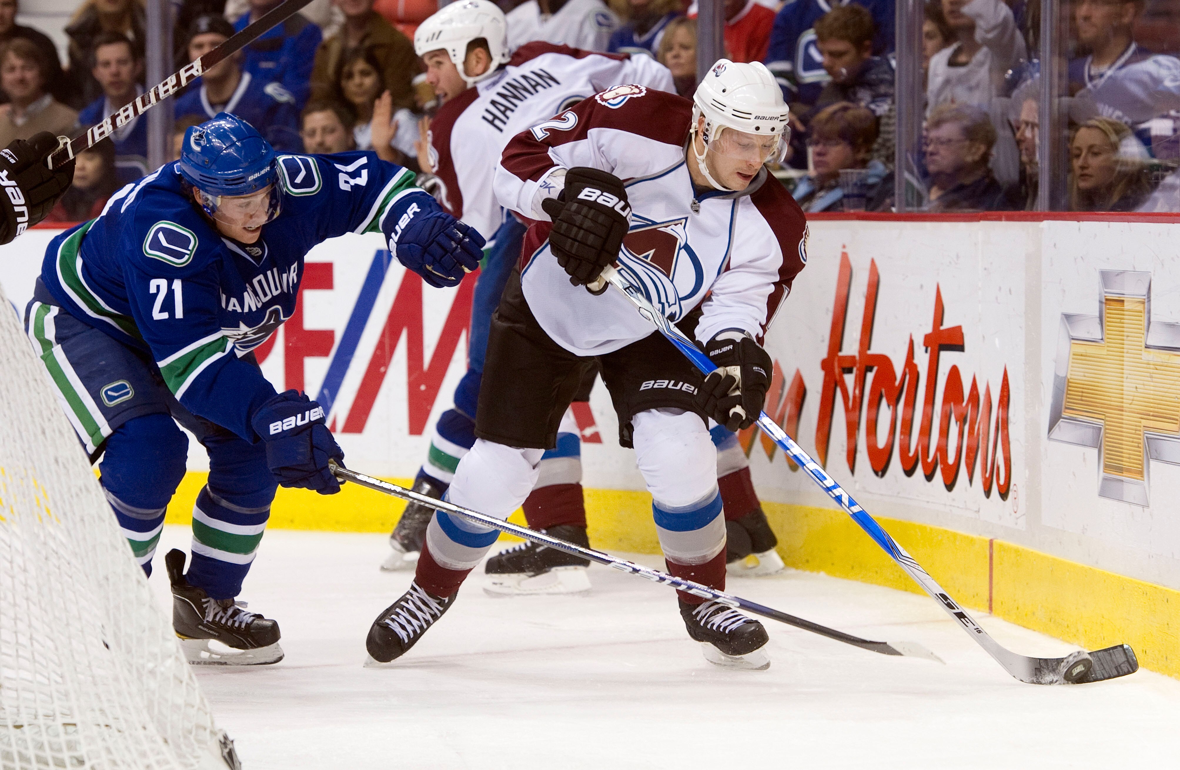 VANCOUVER, CANADA - NOVEMBER 24: Mason Raymond #21 of the Vancouver Canucks tries to check Kevin Porter #12 of the Colorado Avalanche off the puck during the second period in NHL action on November 24, 2010 at Rogers Arena in Vancouver, British Columbia, 