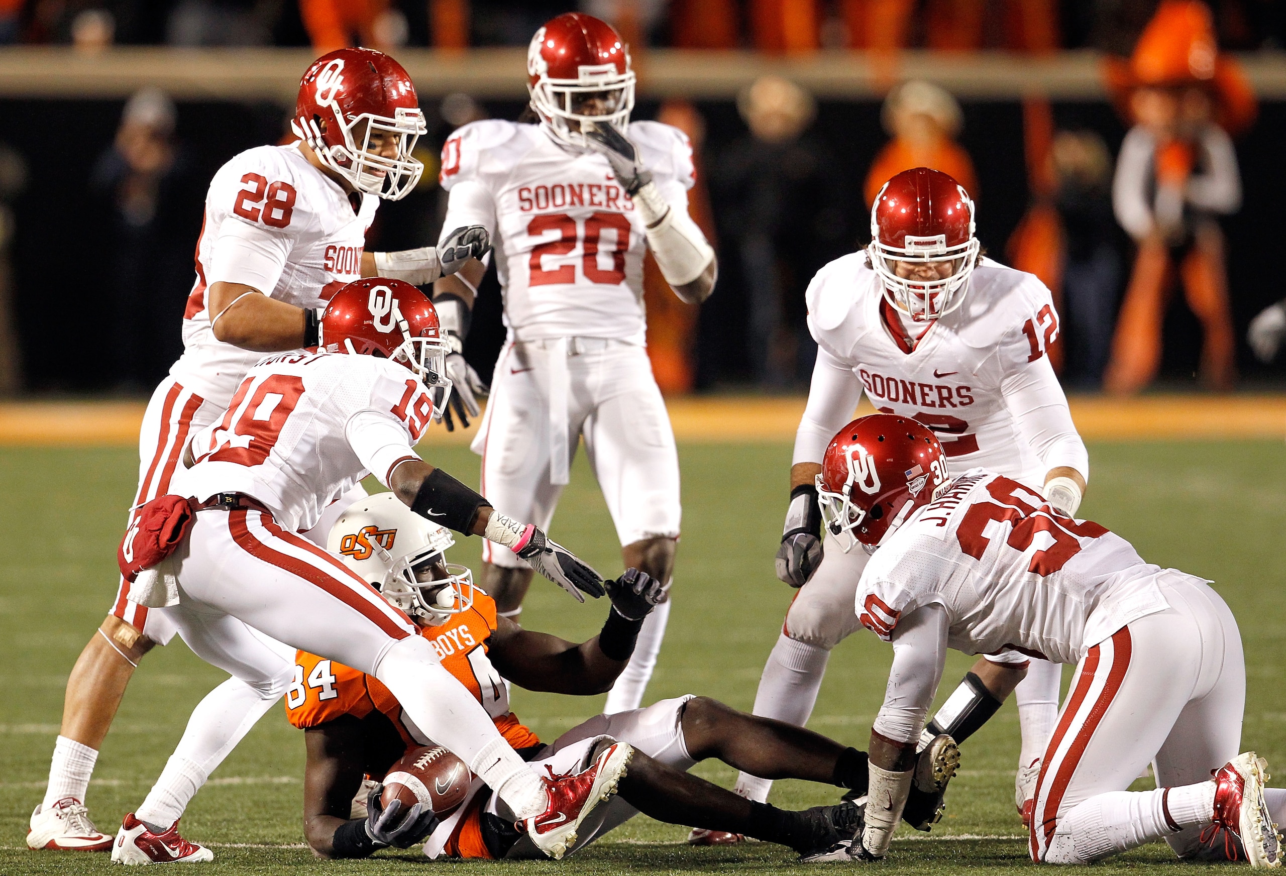 STILLWATER, OK - NOVEMBER 27:  Receiver Hubert Anyiam #84 of the Oklahoma State Cowboys is surrounded by the Oklahoma Sooners defense at Boone Pickens Stadium on November 27, 2010 in Stillwater, Oklahoma.  The Sooners beat the Cowboys 47-41.  (Photo by To