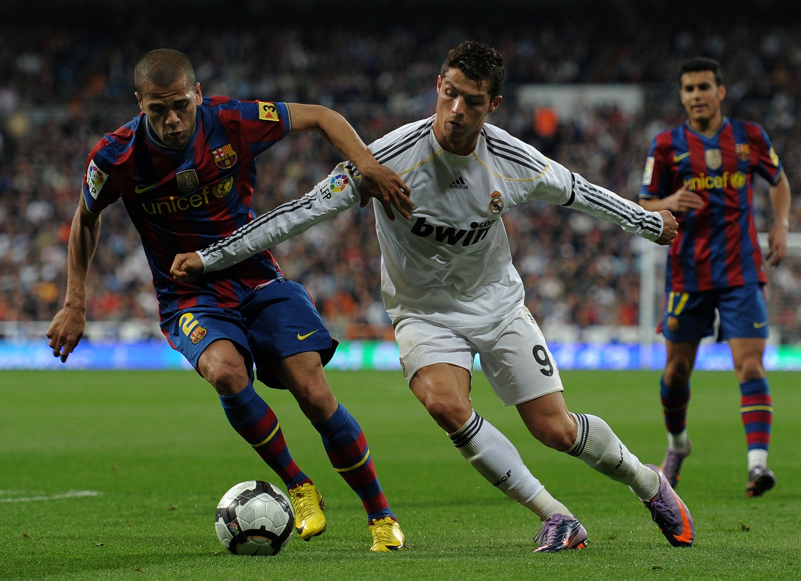 MADRID, SPAIN - APRIL 10:  Cristiano Ronaldo (R) of Real Madrid fights for the ball with Daniel Alves of FC Barcelona during the La Liga match between Real Madrid and Barcelona at the Estadio Santiago Bernabeu on April 10, 2010 in Madrid, Spain. Barcelona
