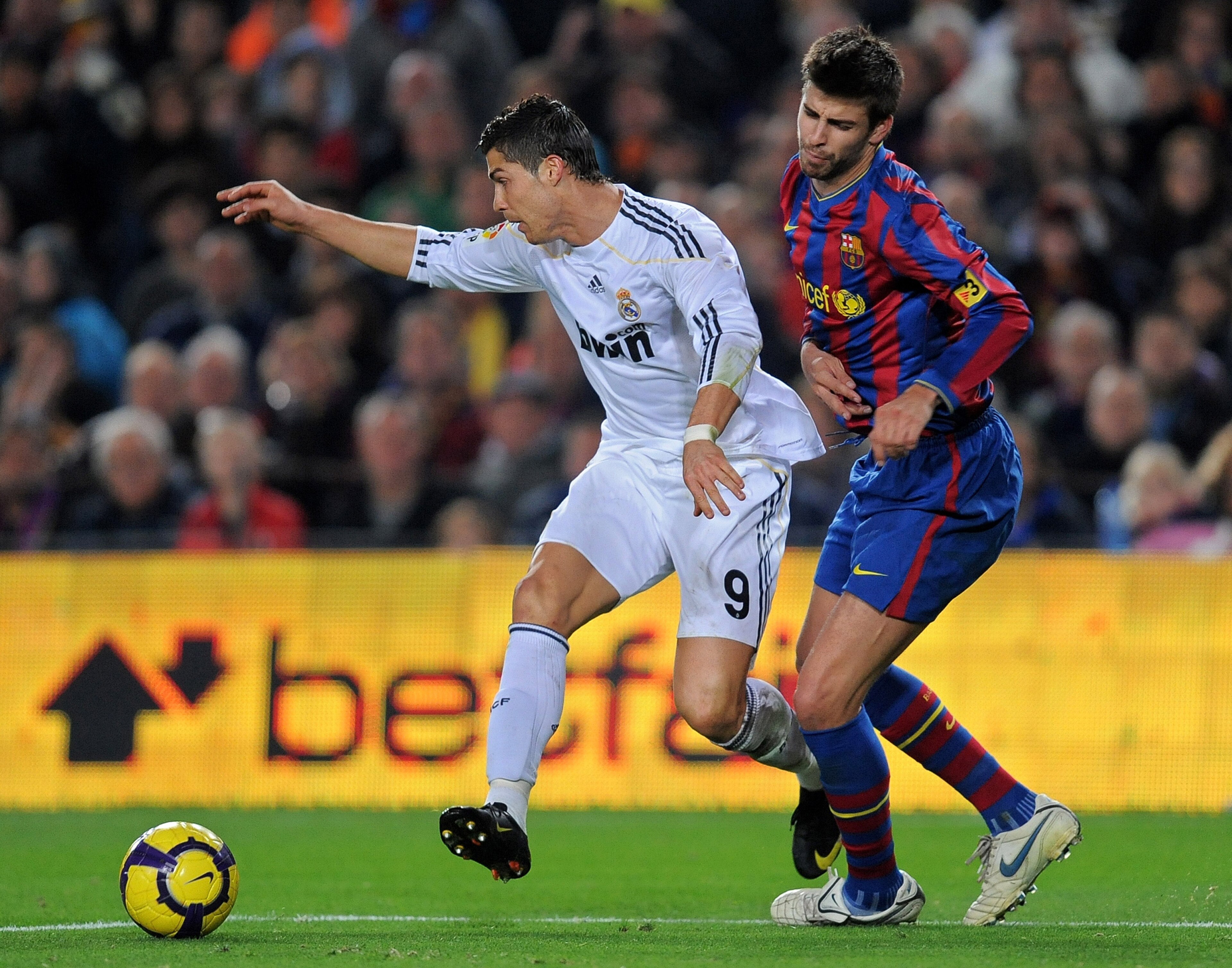 BARCELONA, SPAIN - NOVEMBER 29:  Cristiano Ronaldo (L) of Real Madrid duels for the ball with Gerard Pique of FC Barcelona during the La Liga match between Barcelona and Real Madrid at the Camp Nou Stadium on November 29, 2009 in Barcelona, Spain. Barcelo