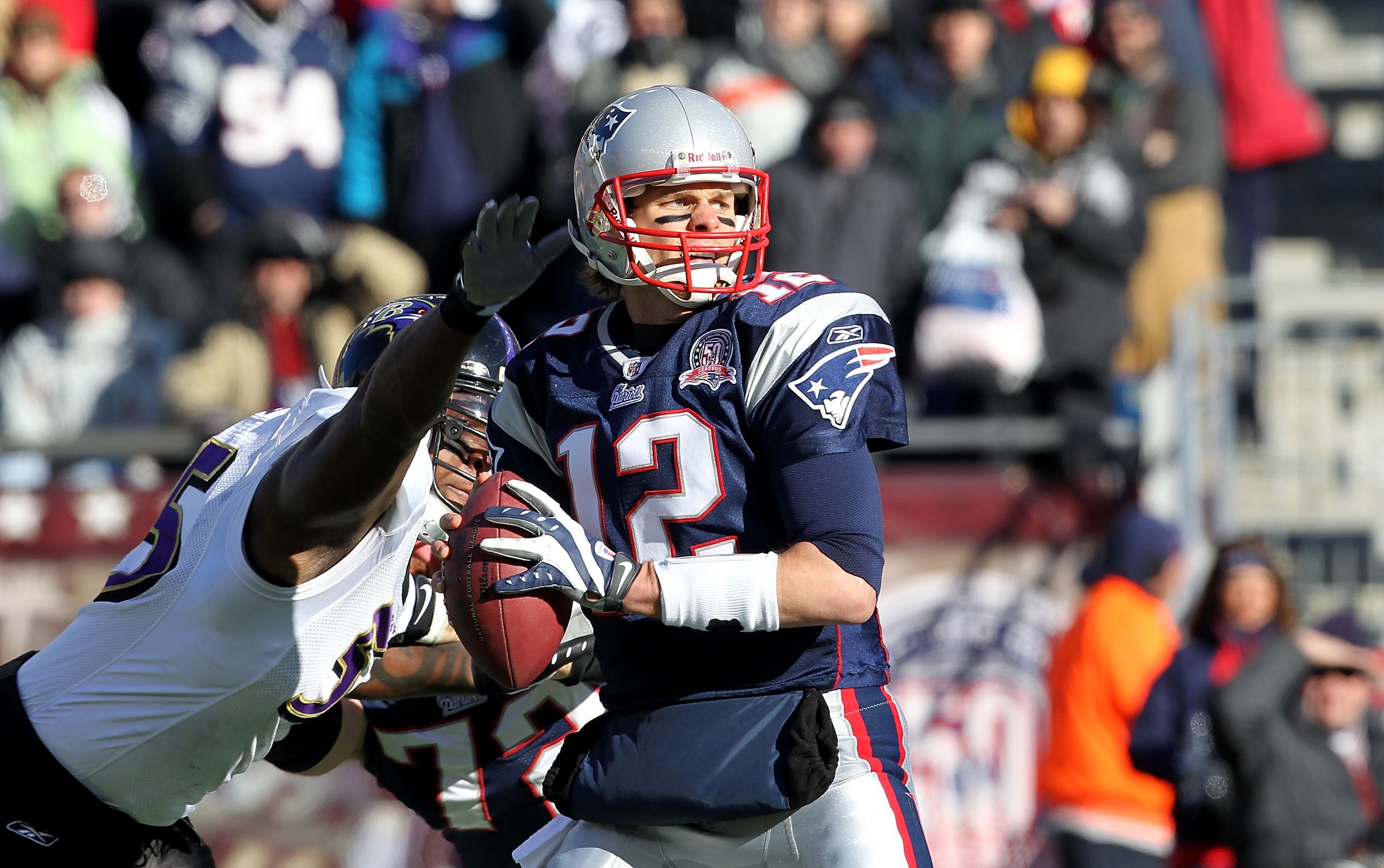 FOXBORO, MA - JANUARY 10:  Tom Brady #12 of the New England Patriots looks to pass against pressure from Terrell Suggs #55 of the Baltimore Ravens during the 2010 AFC wild-card playoff game at Gillette Stadium on January 10, 2010 in Foxboro, Massachusetts