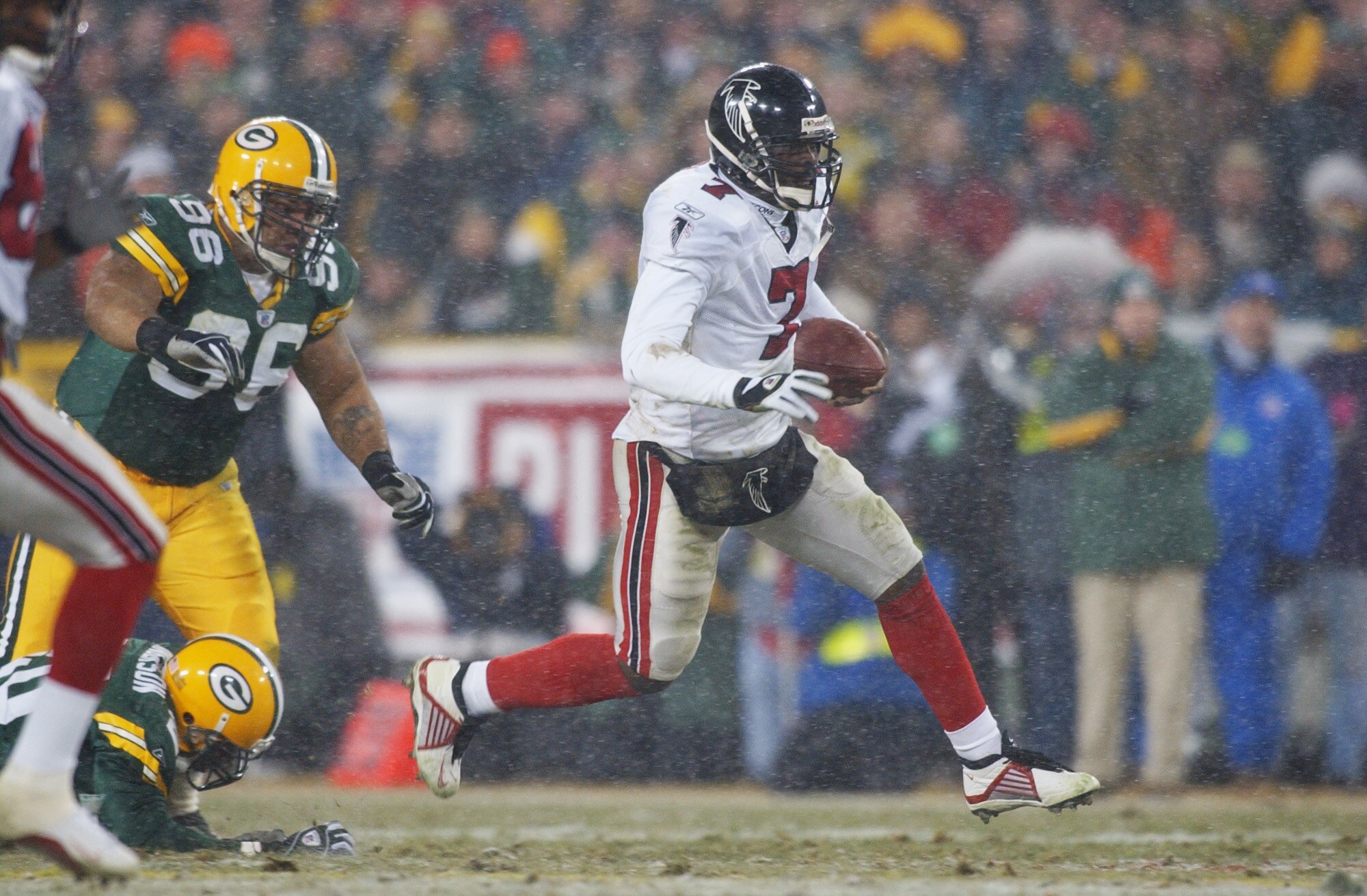 GREEN BAY, WI - JANUARY 4:  Michael Vick #7 of the Atlanta Falcons runs out of the pocket against the Green Bay Packers during the NFC Wildcard game on January 4, 2002 at Lambeau Field in Green Bay, Wisconsin.  (Photo by Jonathan Daniel/Getty Images)