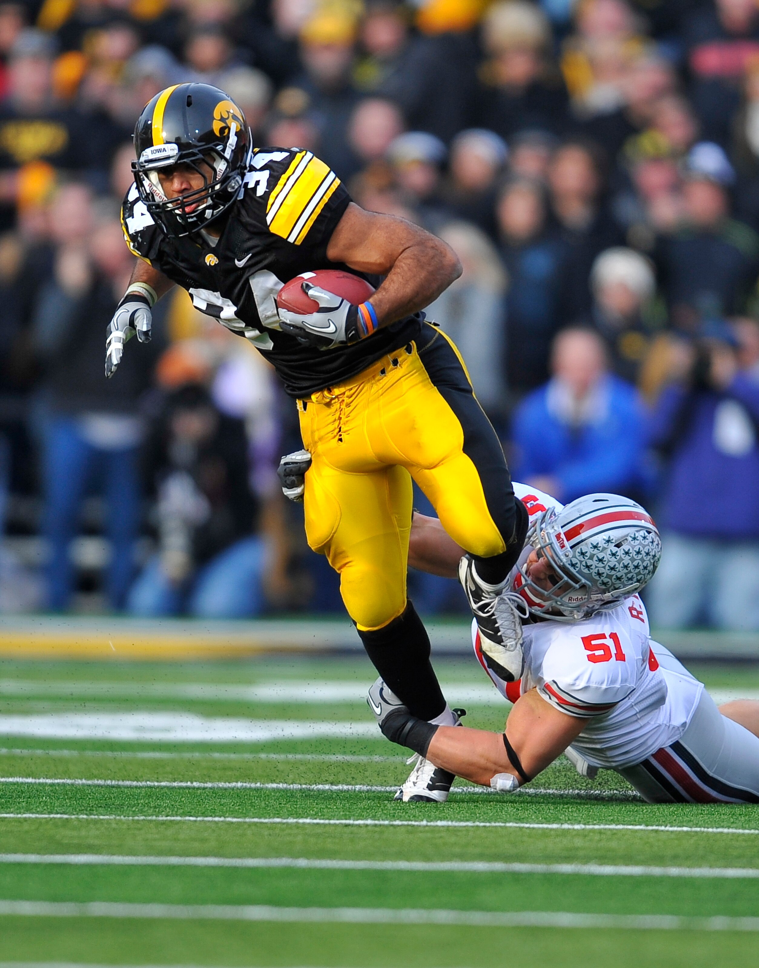 IOWA CITY, IA - NOVEMBER 20:  Running back Marcus Coker #34 of the University of Iowa Hawkeyes is tackled by linebacker Ross Homan #51 of the Ohio State Buckeyes during the first half of play at Kinnick Stadium on November 20, 2010 in Iowa City, Iowa. Ohi