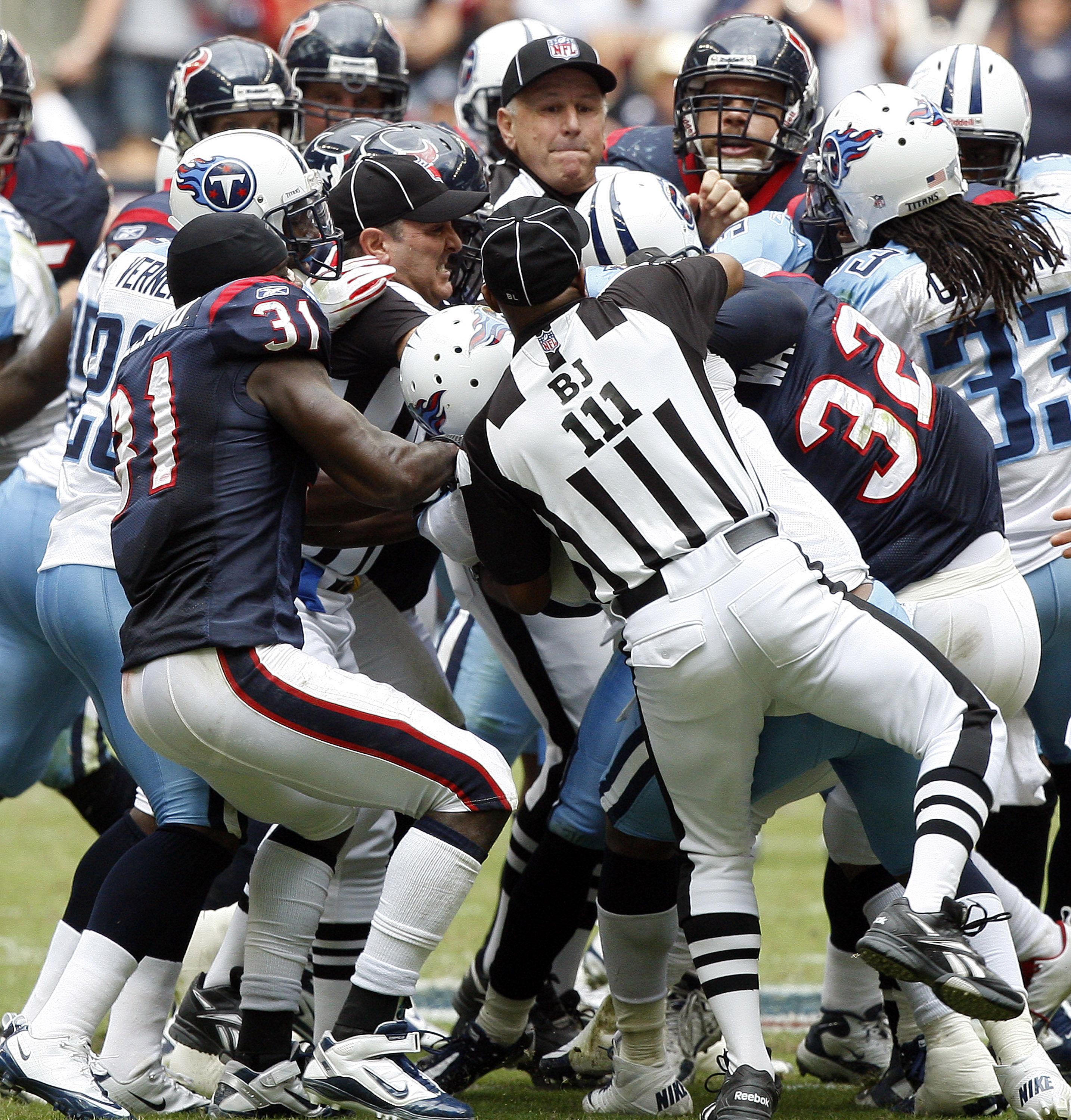 HOUSTON - NOVEMBER 28:  Officials attempt to separate players from both the Houston Texans and Tennessee Titans after a bench emptying brawl in the fourth quarter that was started by Andre Johnson of the Houston Texans and Cortland Finnegan of the Tenness