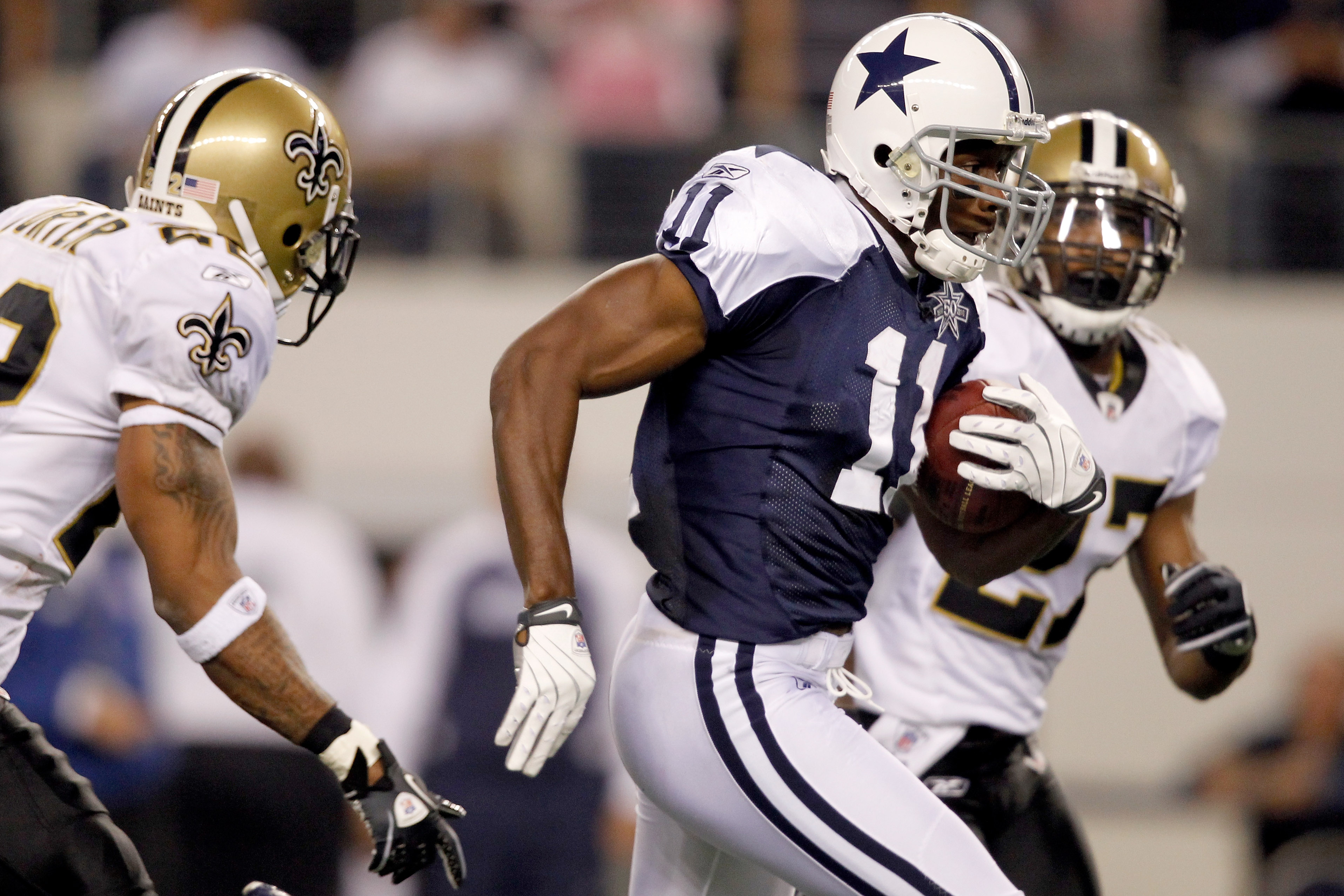 ARLINGTON, TX - NOVEMBER 25: Roy Williams #11 of the Dallas Cowboys carries the ball after making a reception  while being pursued by Malcolm Jenkins #27  of the New Orleans Saints at Cowboys Stadium on November 25, 2010 in Arlington, Texas. Jenkins would